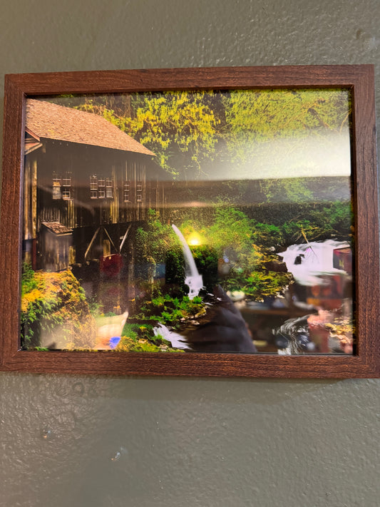 Bring the quiet beauty of a forest waterfall into your home with this framed 8×10 nature photograph. A rustic structure, flowing water, and lush greenery create a peaceful Pacific Northwest-inspired landscape.