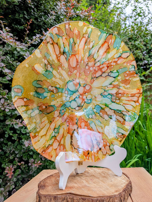 Bring color and light to your home or garden with this contemporary scalloped art glass bowl. Featuring warm golden tones accented by olive green, amber, turquoise, and shimmering metallic highlights, it serves beautifully as a centerpiece, decorative bowl, or tabletop bird bath.