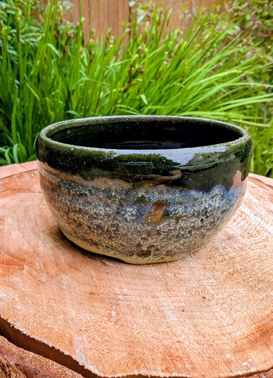 A beautifully hand-thrown studio pottery bowl featuring a rich olive green interior and layered blue, cream, and earthy brown glaze. Signed by the artist, this compact stoneware piece blends functional craftsmanship with timeless Pacific Northwest style.