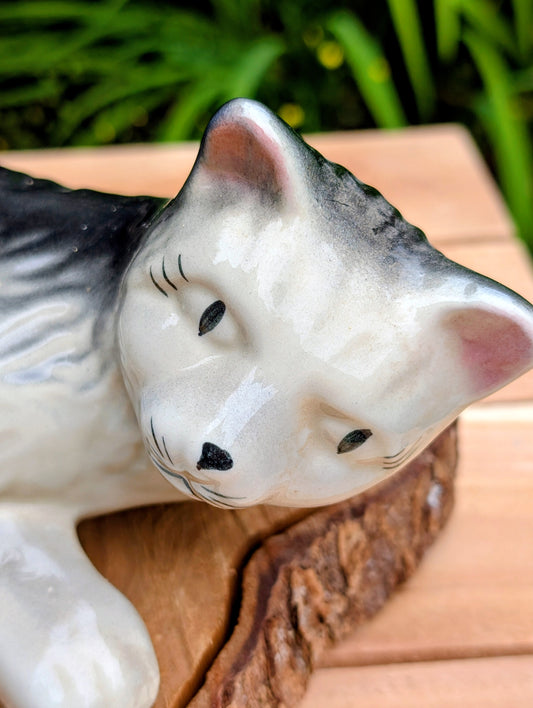 Bring a touch of mid-century whimsy to your home or garden with this vintage hand-painted ceramic wall hugger cat. Its generous 14-inch size, expressive face, and glossy gray-and-black finish make it a charming collectible for cat lovers and vintage décor enthusiasts alike.
