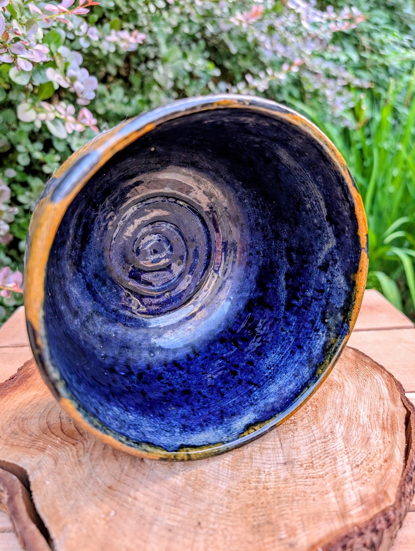 A beautifully hand-thrown studio pottery bowl featuring a rich cobalt blue interior, earthy ochre exterior, and expressive black drip glaze. Its timeless craftsmanship and organic design make it equally suited for serving, display, or adding artisan character to any Pacific Northwest-inspired home.