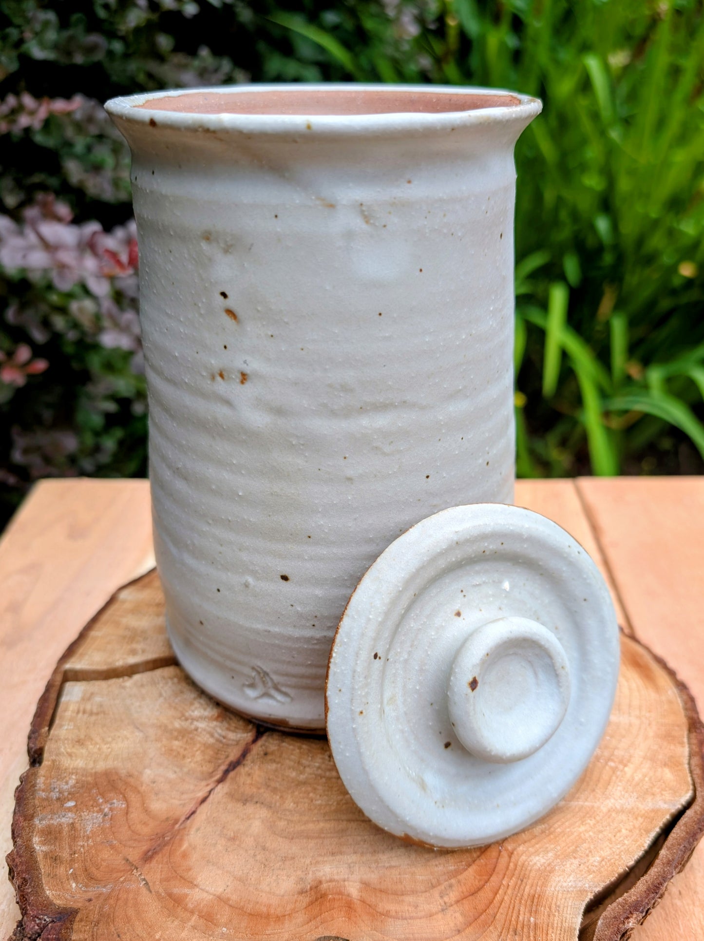Bring warmth and handcrafted character to your kitchen with this wheel-thrown stoneware canister. Finished in a soft creamy-white glaze with subtle iron speckling, this timeless storage vessel blends rustic craftsmanship with modern organic design.