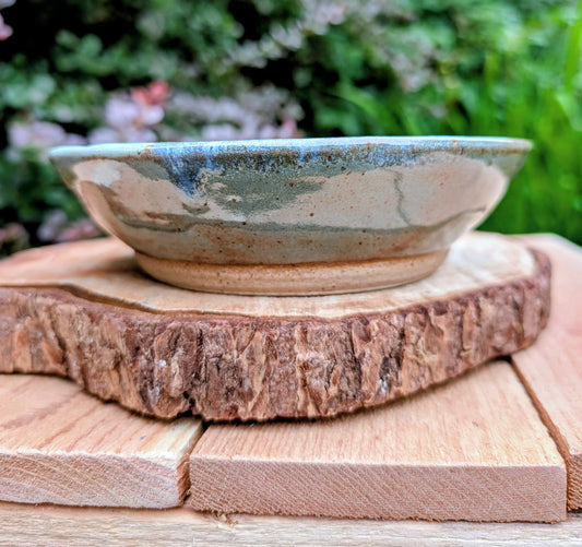 Bring the calming colors of the Pacific Northwest into your home with this handcrafted studio pottery bowl. Featuring layered blue, aqua, cream, and olive reactive glazes, this artisan stoneware piece is equally beautiful as a serving bowl or decorative display.