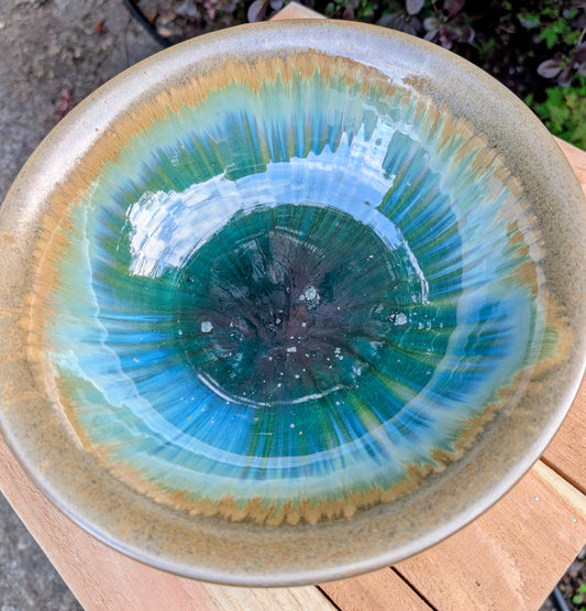 A beautifully handcrafted studio pottery bowl featuring layered blue, celadon, and copper reactive glazes with striking crystalline patterning. This artisan stoneware piece makes an eye-catching centerpiece or decorative accent inspired by the colors of Pacific Northwest waters.