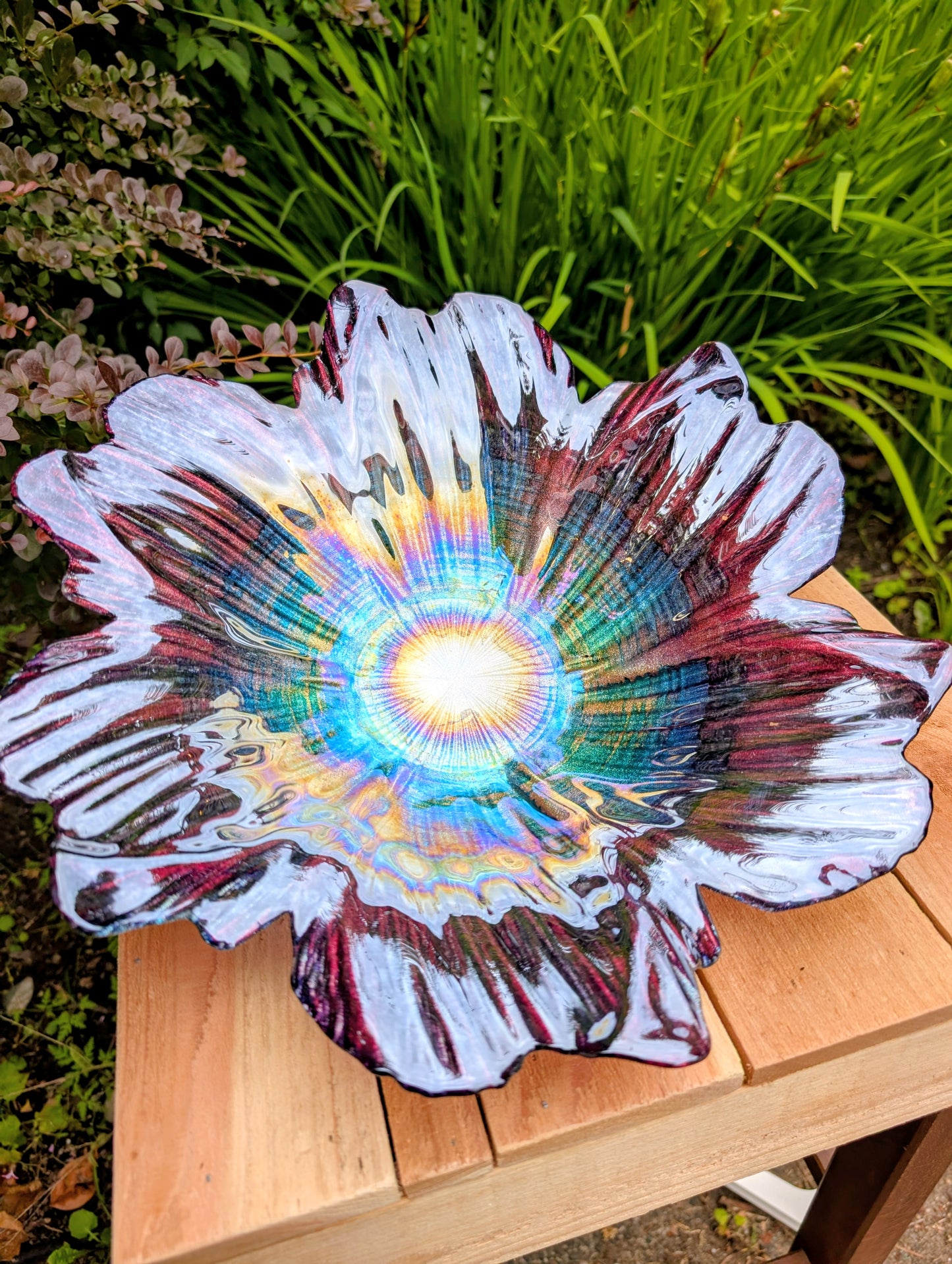Bring color and artistry to your home or garden with this iridescent art glass floral bowl. Featuring shimmering purple and blue hues, it serves beautifully as either a striking tabletop centerpiece or a decorative bird bath bowl.