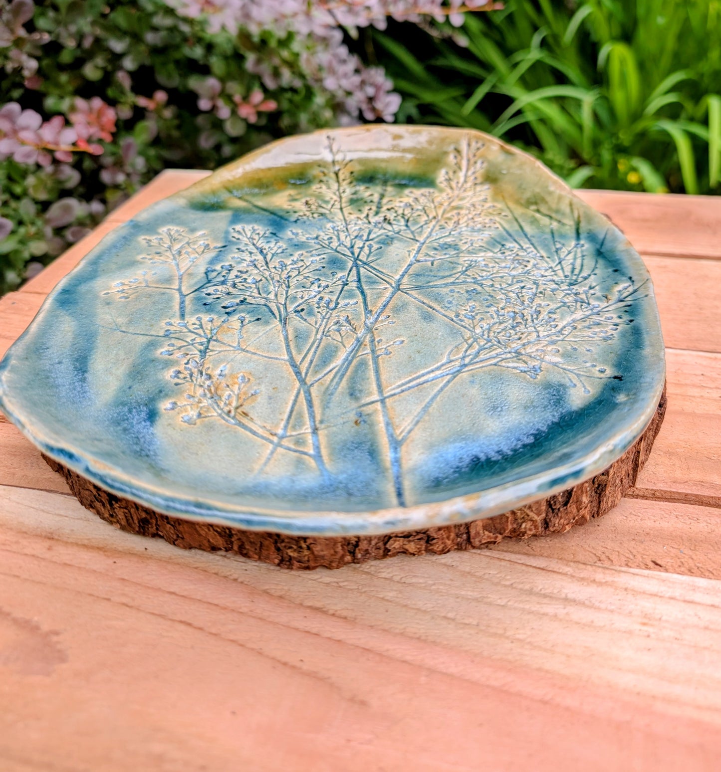 Celebrate the beauty of nature with this signed handbuilt studio pottery platter featuring an elegant botanical relief impressed directly into the clay. Finished in layered blue, teal, and olive glazes, this contemporary stoneware piece is equally at home as functional serveware or displayed as ceramic wall art.