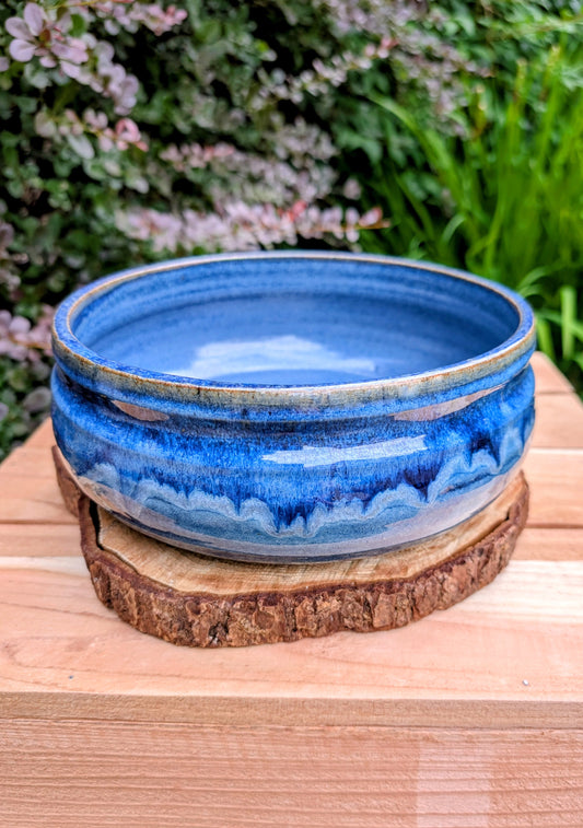 A beautifully hand-thrown studio pottery bowl dated 1990, featuring a rich satin cobalt blue glaze with a subtle spiral movement across the interior. Signed by the artist (maker currently unconfirmed), this functional stoneware piece blends everyday usefulness with timeless handcrafted artistry.