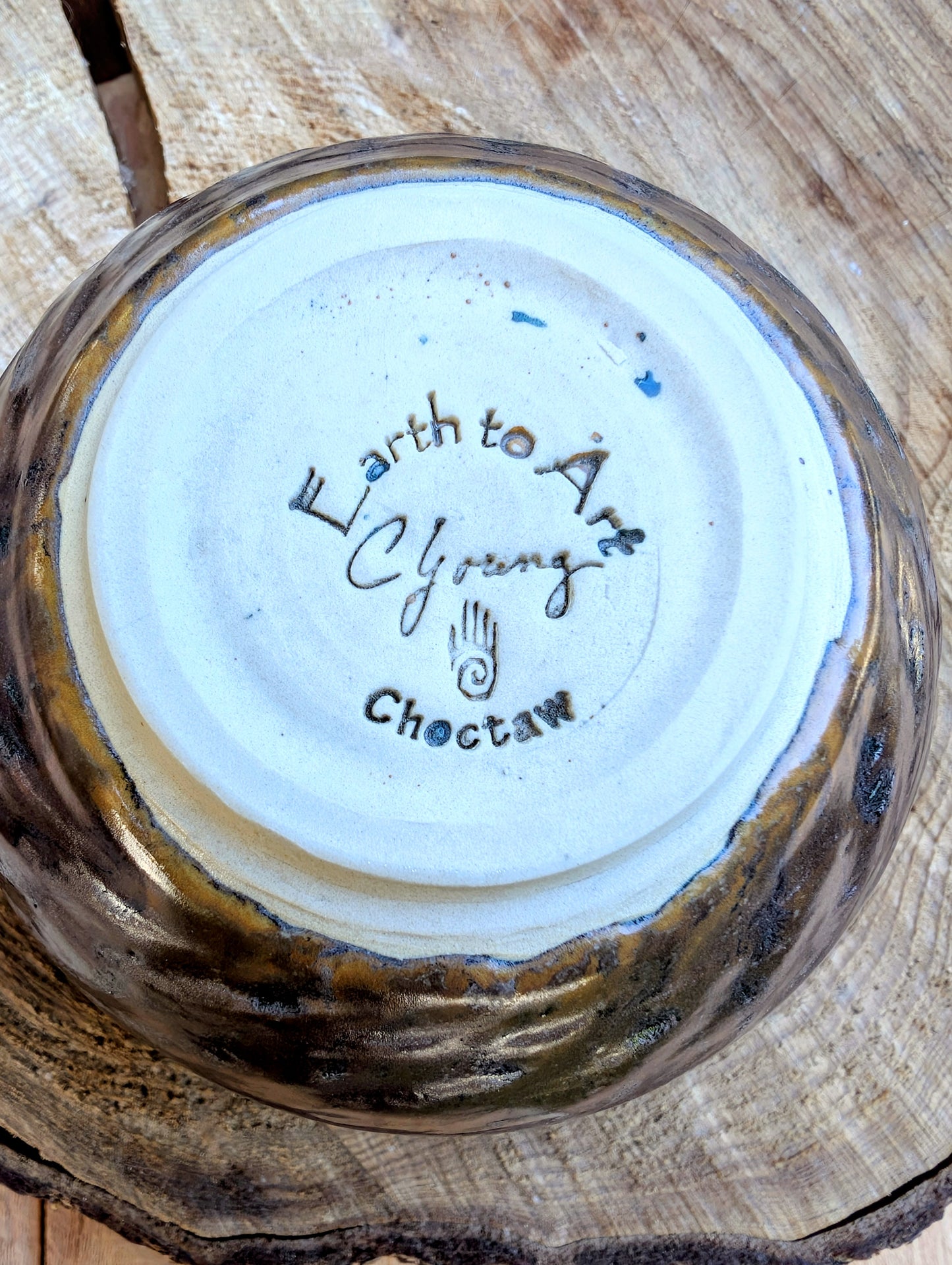 Ceramic bowl with 'Earth to Art Choctaw' branding on a wooden surface