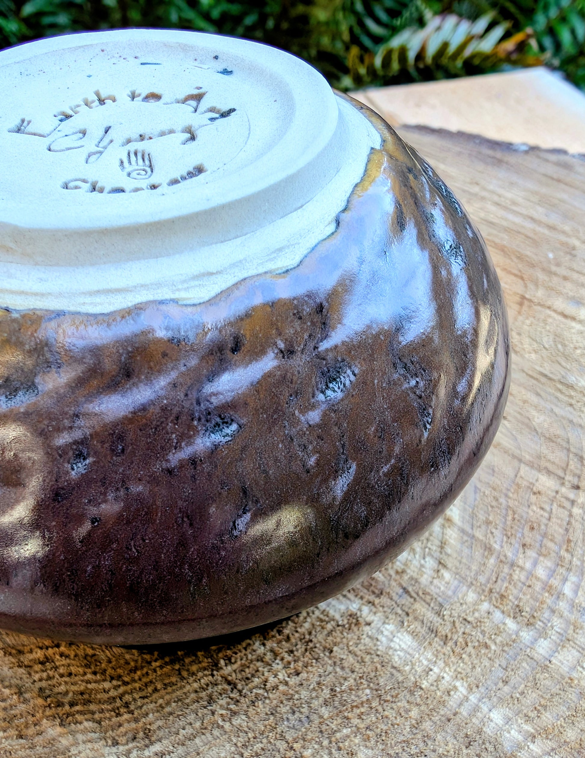 Ceramic bowl with a textured brown glaze on a wooden surface