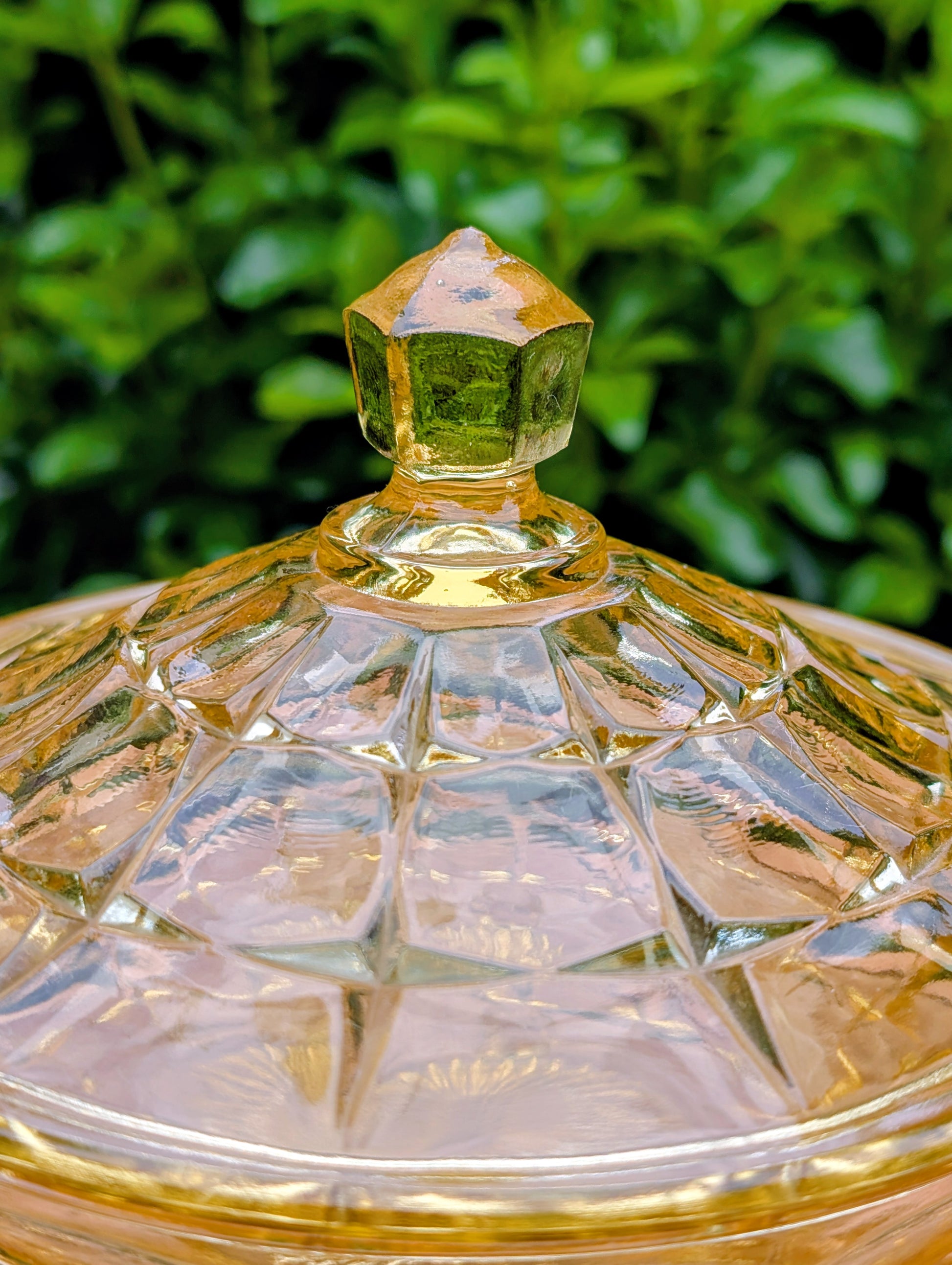 Bring warm vintage charm to your home with this beautiful Tiara Exclusives Constellation covered candy dish in the sought-after Yellow Mist color. Produced by Indiana Glass during the 1970s, its geometric star pattern and golden glow make it a timeless piece for entertaining or display.