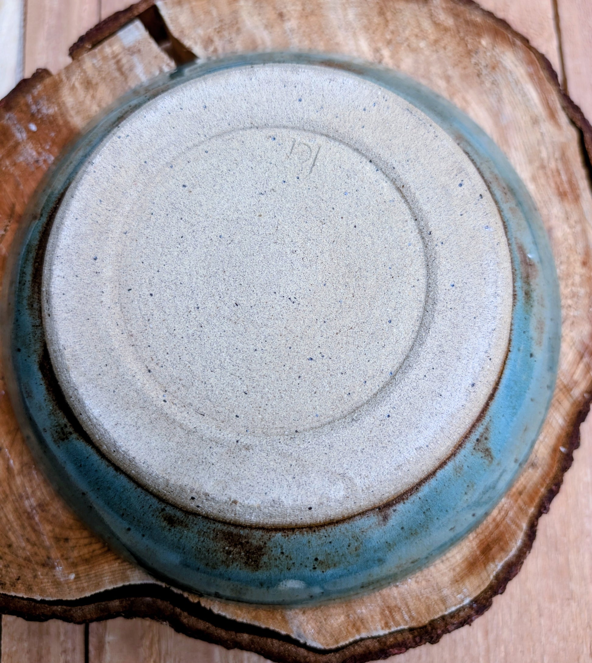 Bring the calming colors of the Pacific Northwest into your home with this handcrafted studio pottery bowl. Featuring layered blue, aqua, cream, and olive reactive glazes, this artisan stoneware piece is equally beautiful as a serving bowl or decorative display.