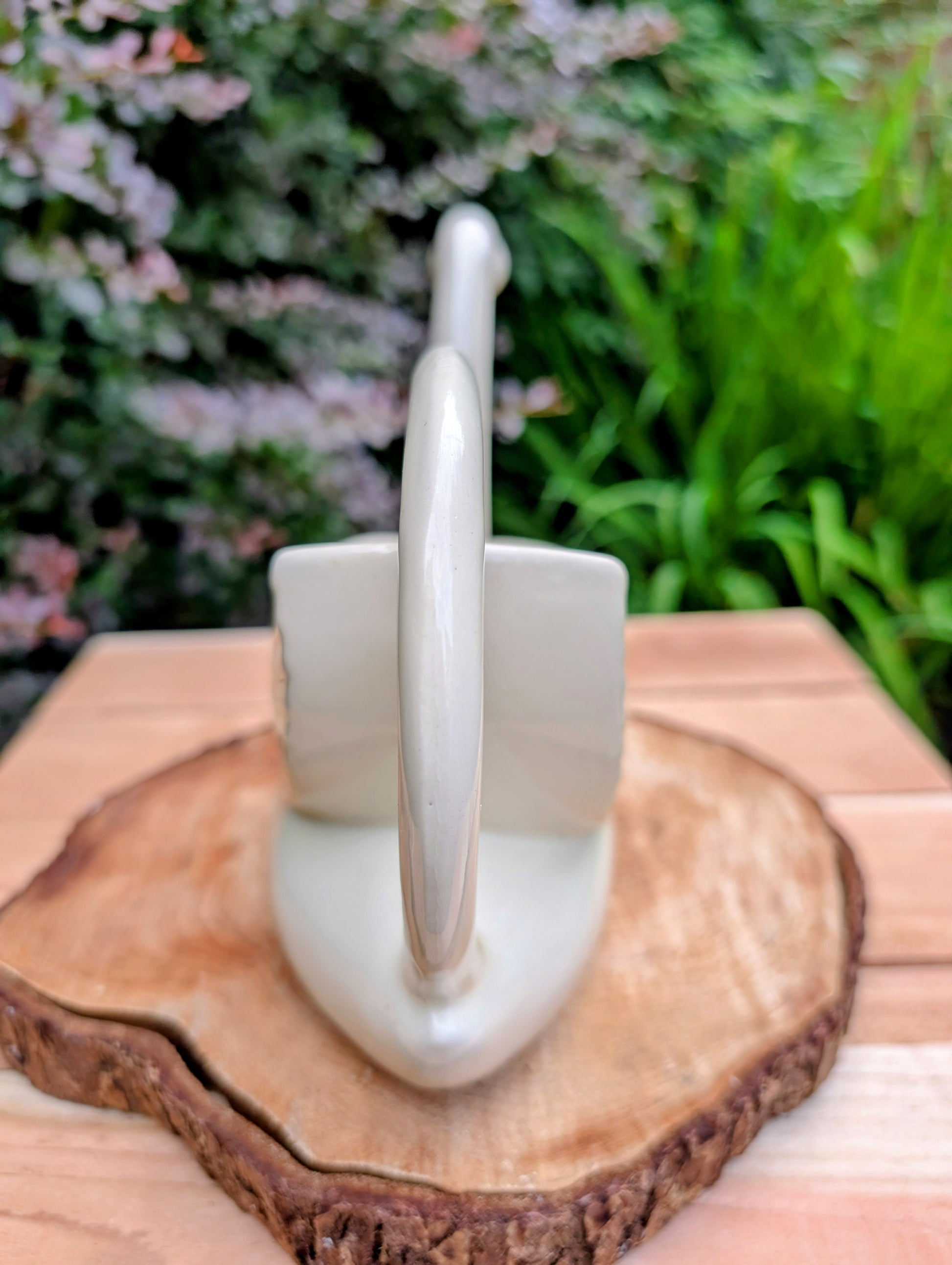 A charming 1950s Nouvelle Pottery swan watering pitcher that blends sculptural beauty with everyday function. Finished in a soft ivory glaze with hand-painted details, this Mid-Century ceramic piece is equally at home caring for houseplants or displayed as timeless vintage décor.