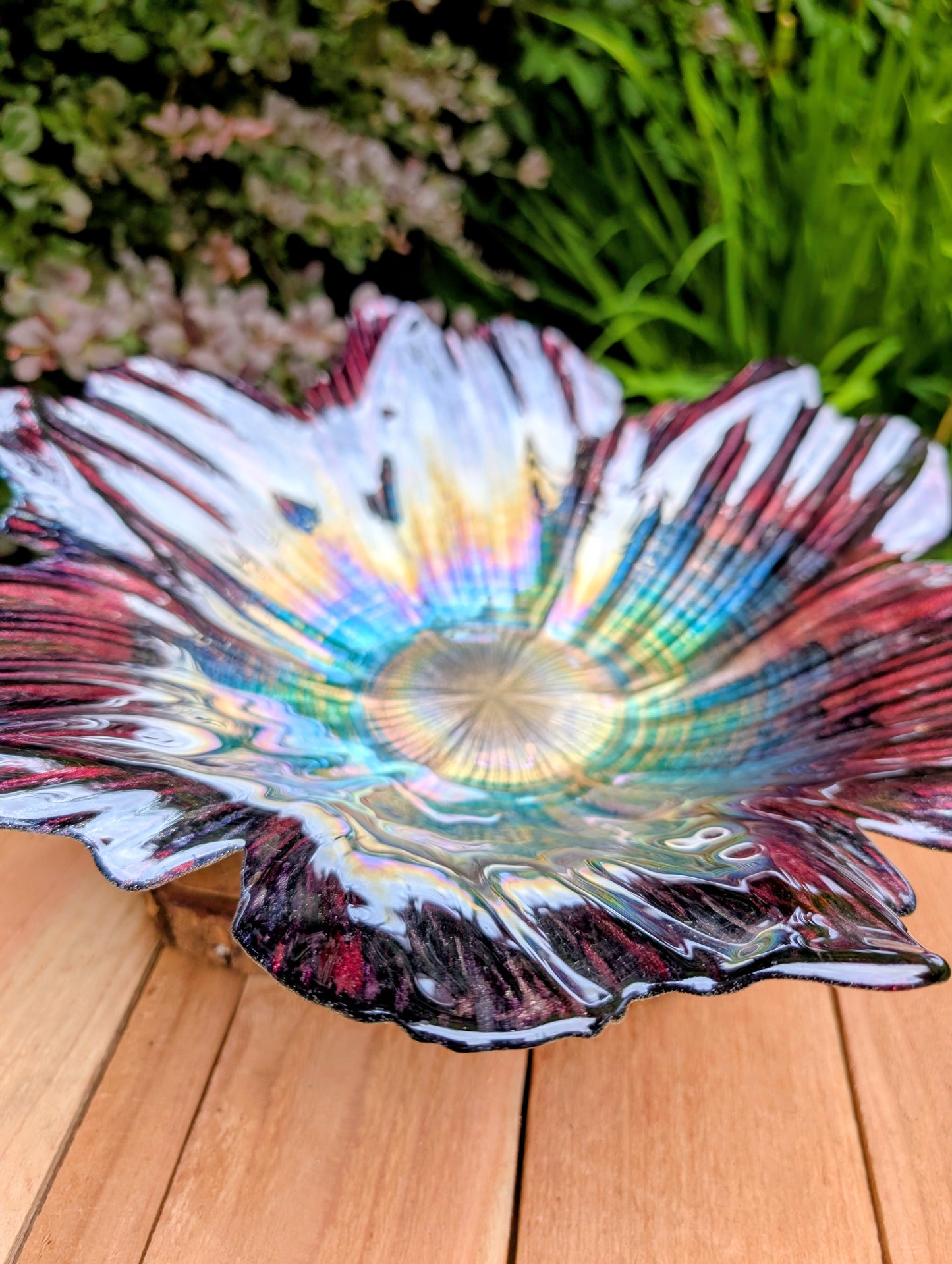 Bring color and artistry to your home or garden with this iridescent art glass floral bowl. Featuring shimmering purple and blue hues, it serves beautifully as either a striking tabletop centerpiece or a decorative bird bath bowl.