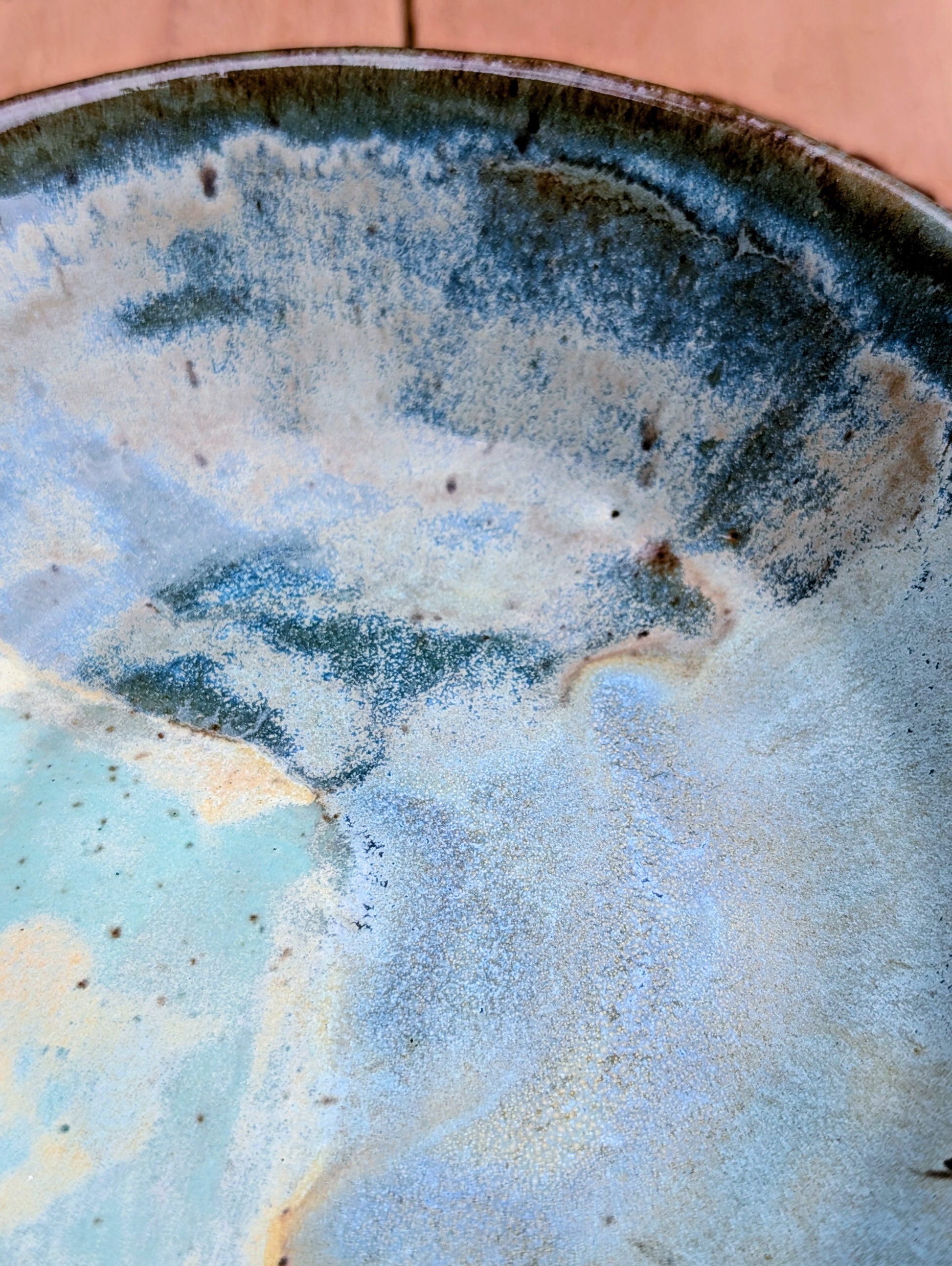 Bring the calming colors of the Pacific Northwest into your home with this handcrafted studio pottery bowl. Featuring layered blue, aqua, cream, and olive reactive glazes, this artisan stoneware piece is equally beautiful as a serving bowl or decorative display.