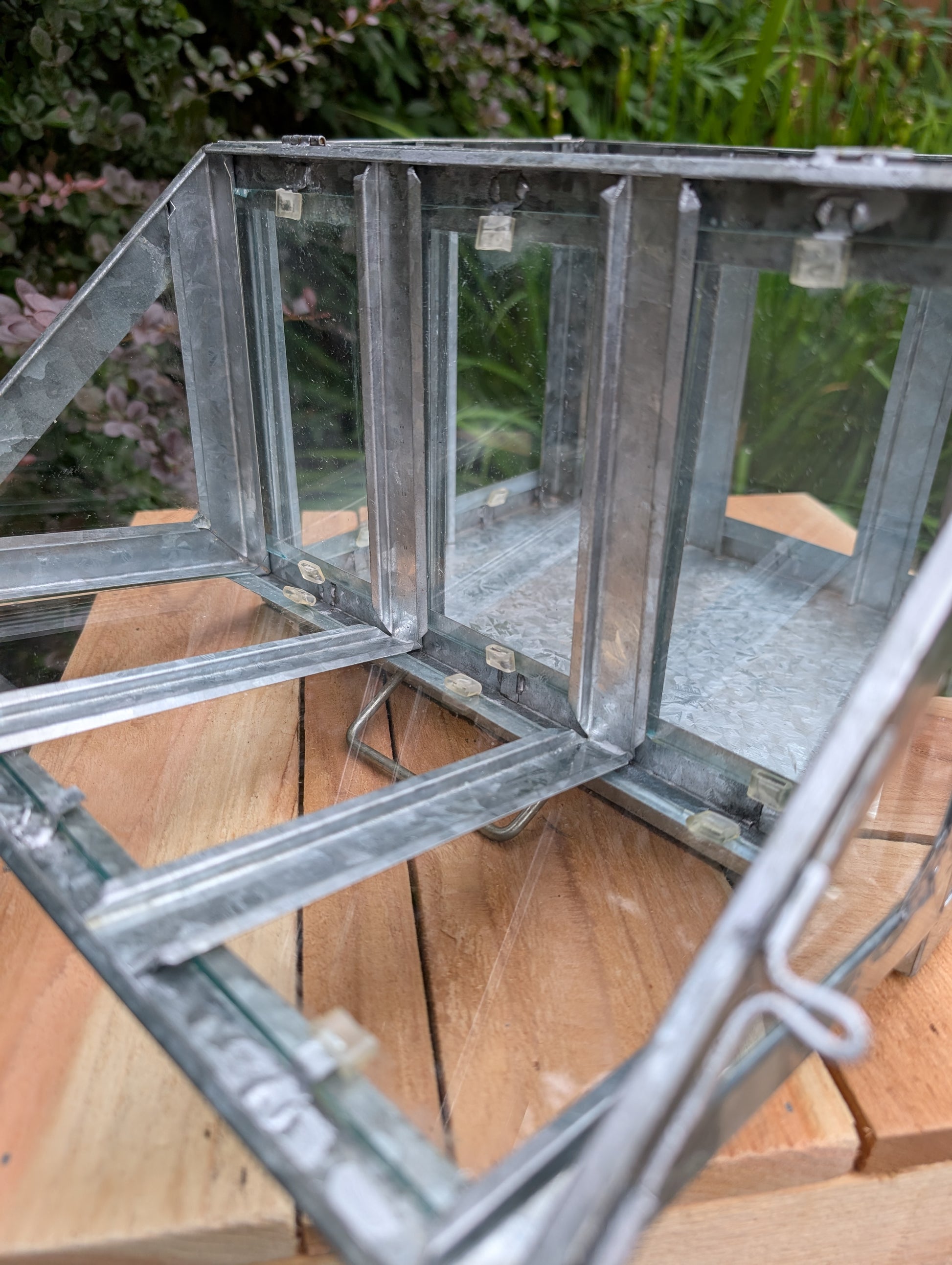 Bring the charm of a Victorian conservatory indoors with this decorative galvanized metal and glass tabletop greenhouse. Perfect for displaying succulents, moss gardens, candles, seasonal décor, or treasured collectibles, it adds timeless botanical style to any room.