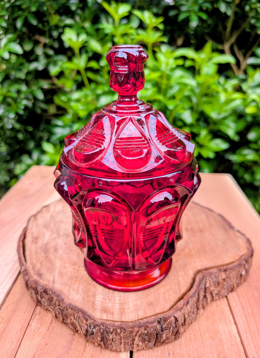 Add timeless elegance to your home with this authentic 1980s Fenton Ruby Red Barred Teardrop Covered Candy Dish. Rich jewel-toned pressed glass, exceptional craftsmanship, and the verified 1980s Fenton maker's mark make this a beautiful display piece for collectors and vintage décor enthusiasts alike.
