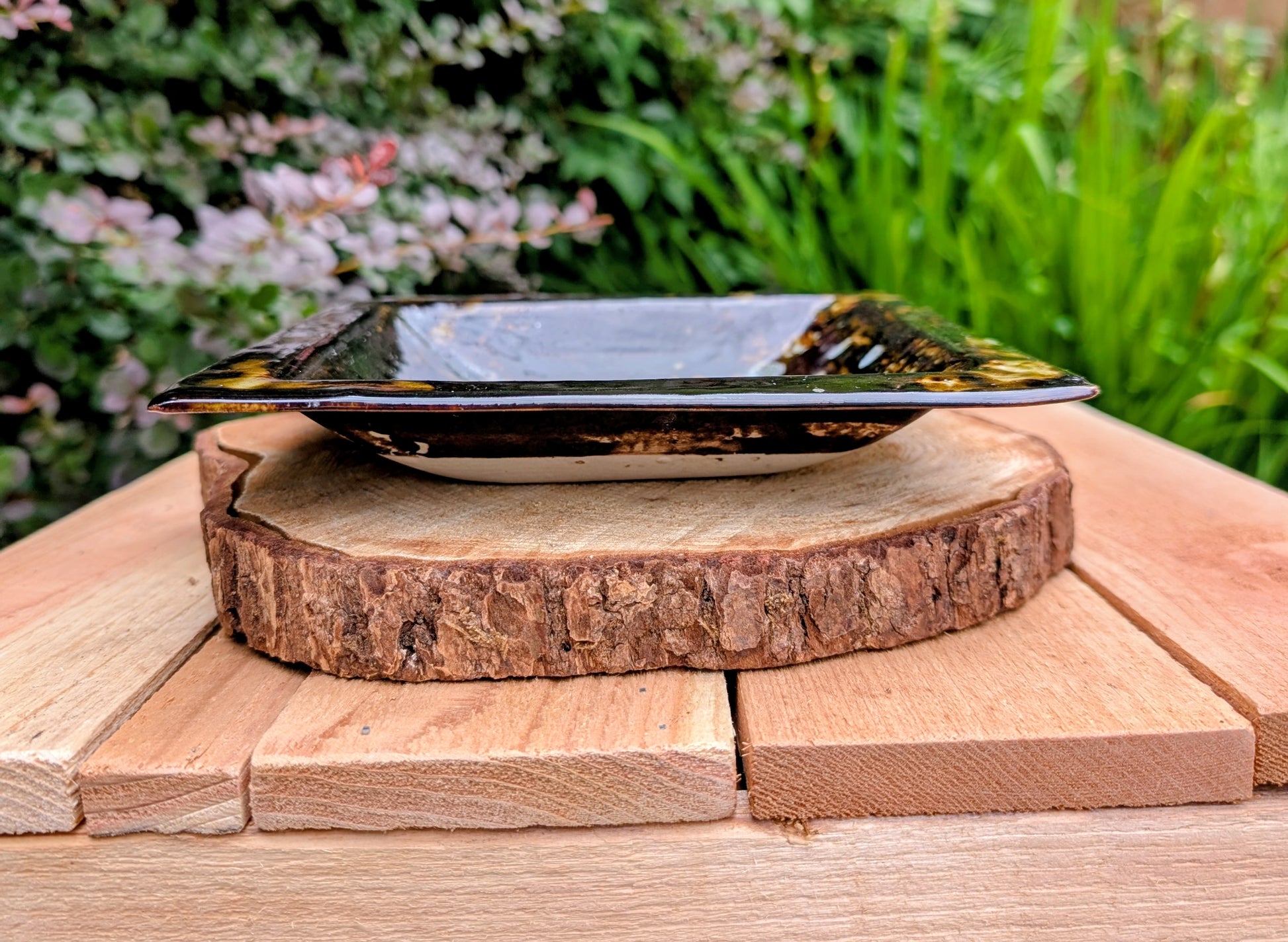 Bring handcrafted artistry into your home with this one-of-a-kind square studio pottery dish. Its rich chocolate brown glaze is accented by constellation-like blue, green, and cream crystalline details, making it equally beautiful as a decorative catchall, appetizer dish, or display piece.