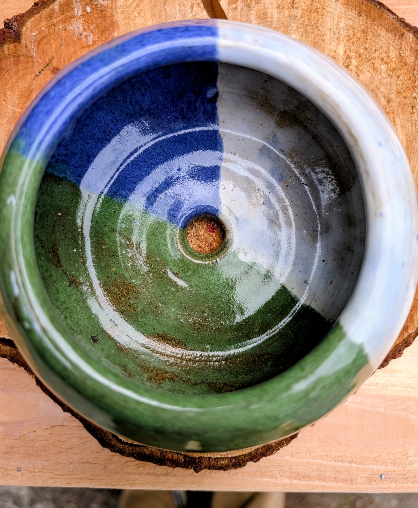 A beautifully hand-thrown studio pottery succulent planter featuring layered blue, moss green, and soft white glazes over high-fired stoneware. Complete with an integrated drainage hole and signed by the artist with the monogram "G.M.," this artisan planter brings handcrafted character to any home or garden.