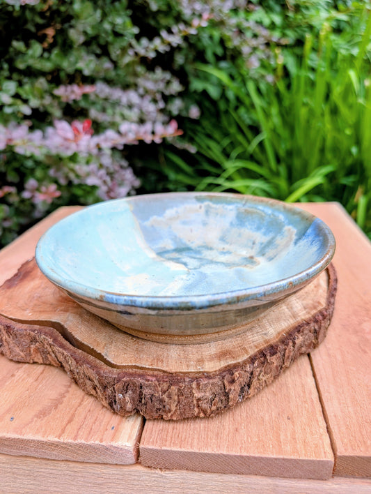 Bring the calming colors of the Pacific Northwest into your home with this handcrafted studio pottery bowl. Featuring layered blue, aqua, cream, and olive reactive glazes, this artisan stoneware piece is equally beautiful as a serving bowl or decorative display.