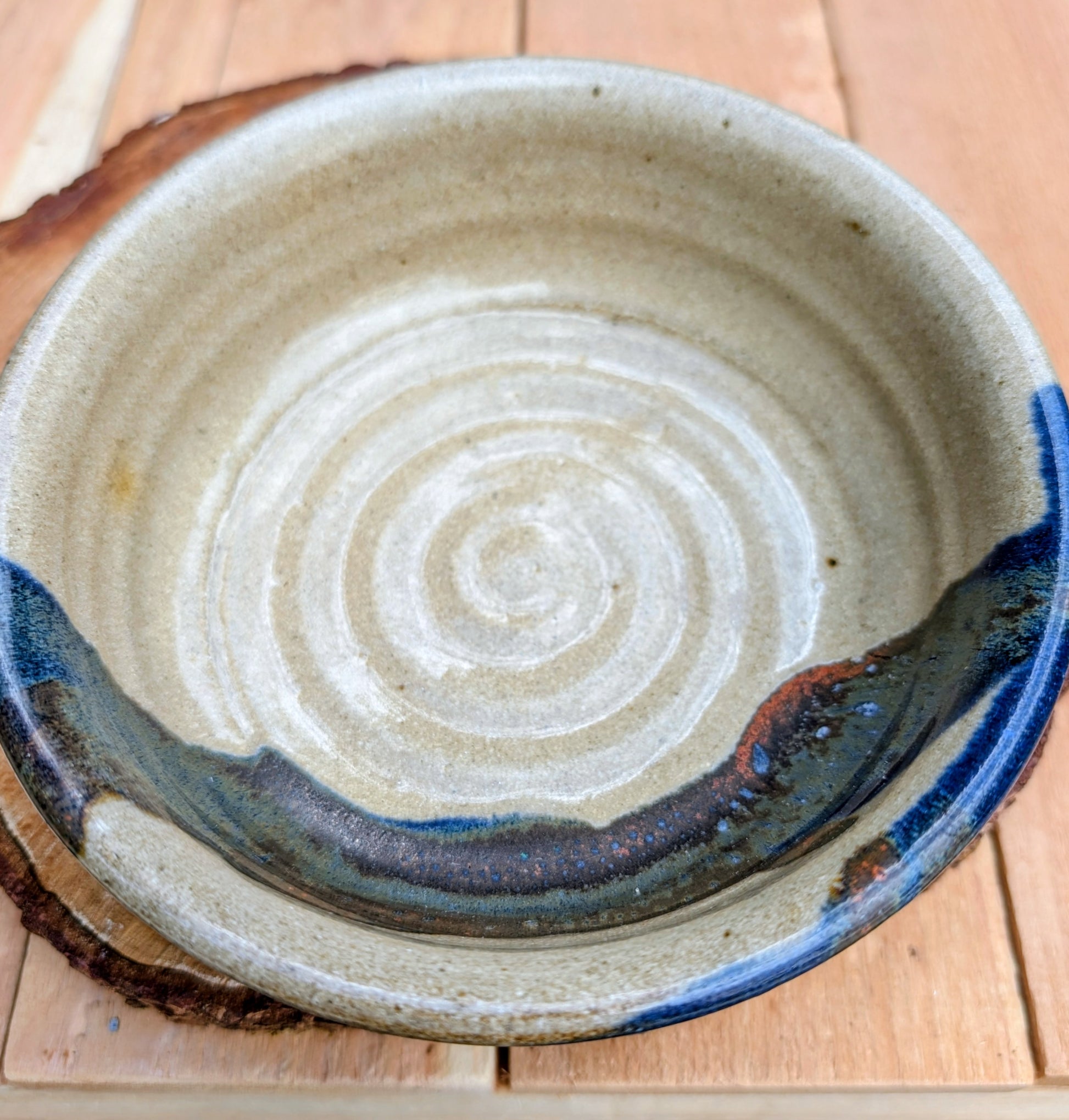 Bring handcrafted warmth to your table with this beautifully wheel-thrown studio pottery bowl, attributed to Gladstone Wear. Featuring flowing cobalt blue, charcoal, and earthy brown glazes over a natural buff stoneware body, it offers timeless artisan appeal for serving or display.