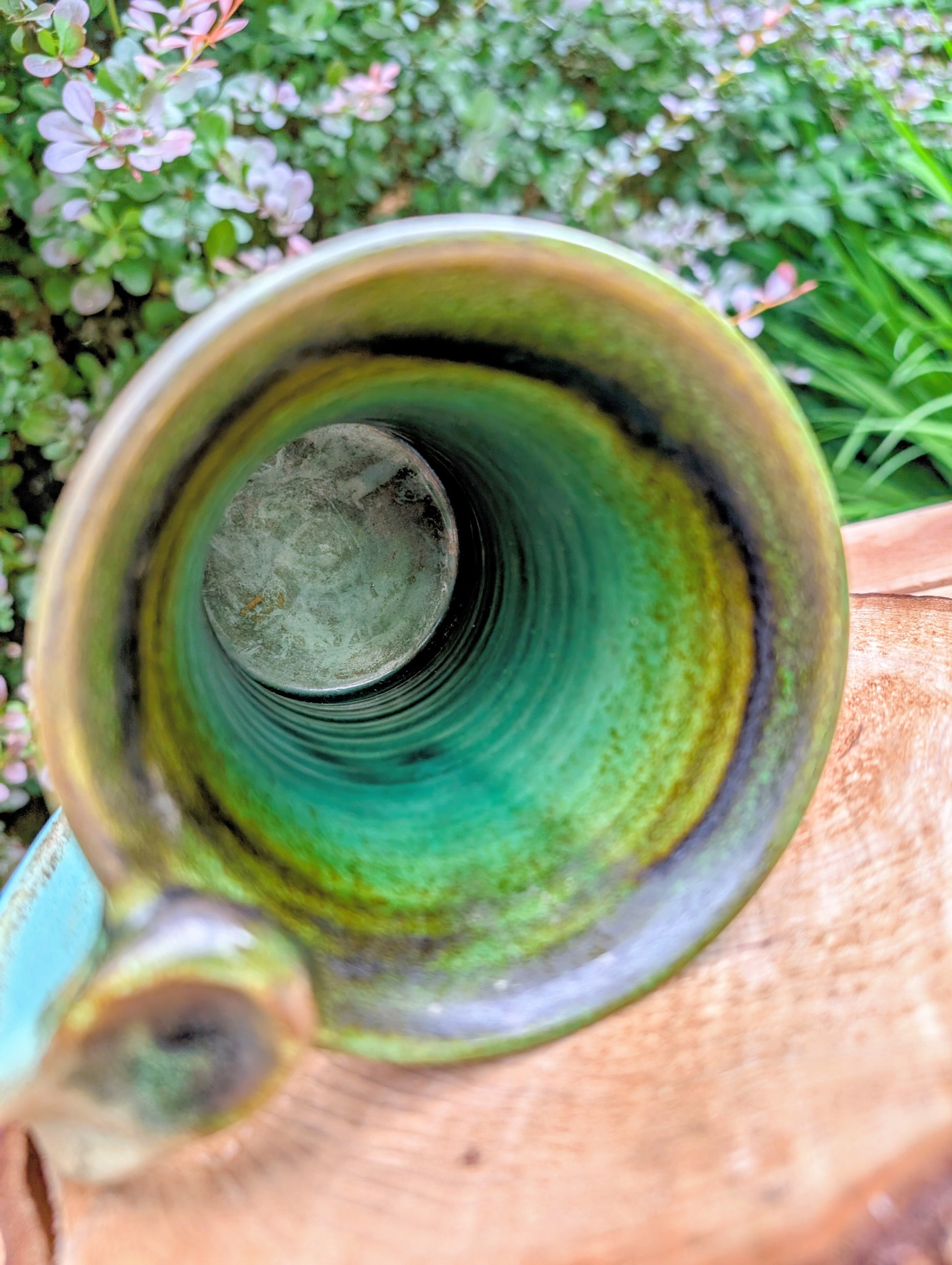 A beautifully handcrafted studio pottery tankard-style mug, wheel-thrown in Hot Springs, Arkansas and dated 2007. Its flowing turquoise, olive, and bronze glaze, generous size, and comfortable thumb-rest handle make it both a functional everyday piece and a collectible example of American studio pottery.