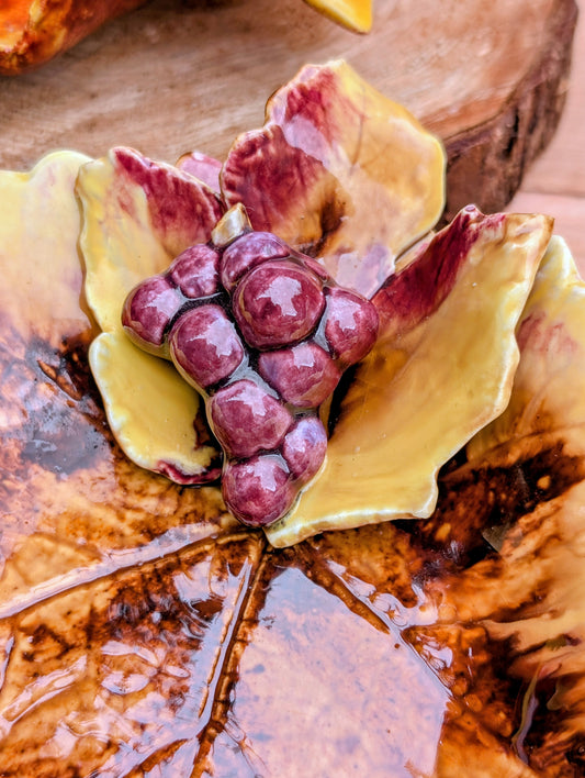 Celebrate the warmth of the harvest season with this charming set of two vintage Lamplite Ceramics leaf-shaped dishes from Fresno, California. Featuring sculpted grape clusters and rich autumn-inspired glazes, these decorative trays bring timeless vineyard style to seasonal entertaining and home décor.