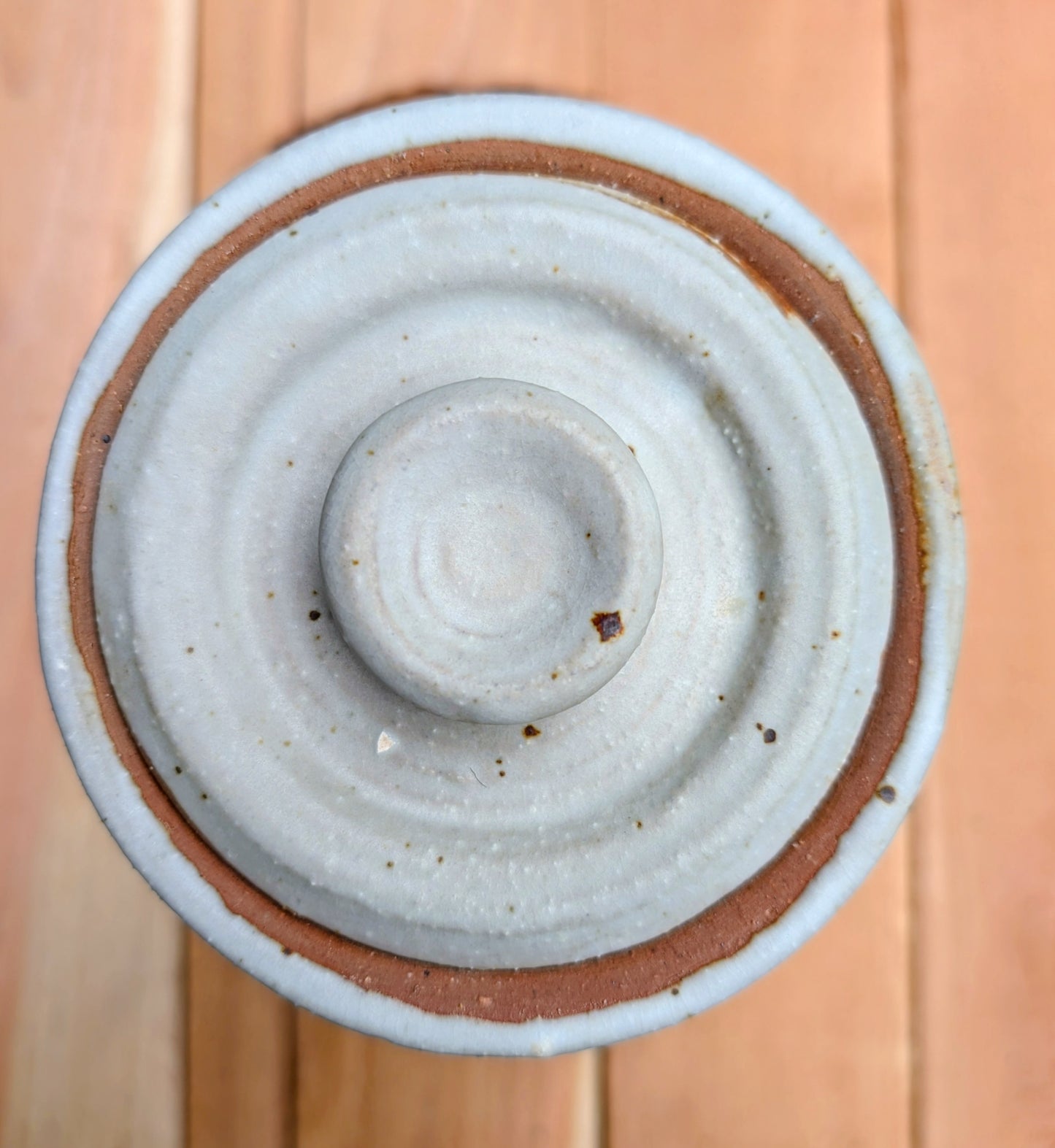 Bring warmth and handcrafted character to your kitchen with this wheel-thrown stoneware canister. Finished in a soft creamy-white glaze with subtle iron speckling, this timeless storage vessel blends rustic craftsmanship with modern organic design.