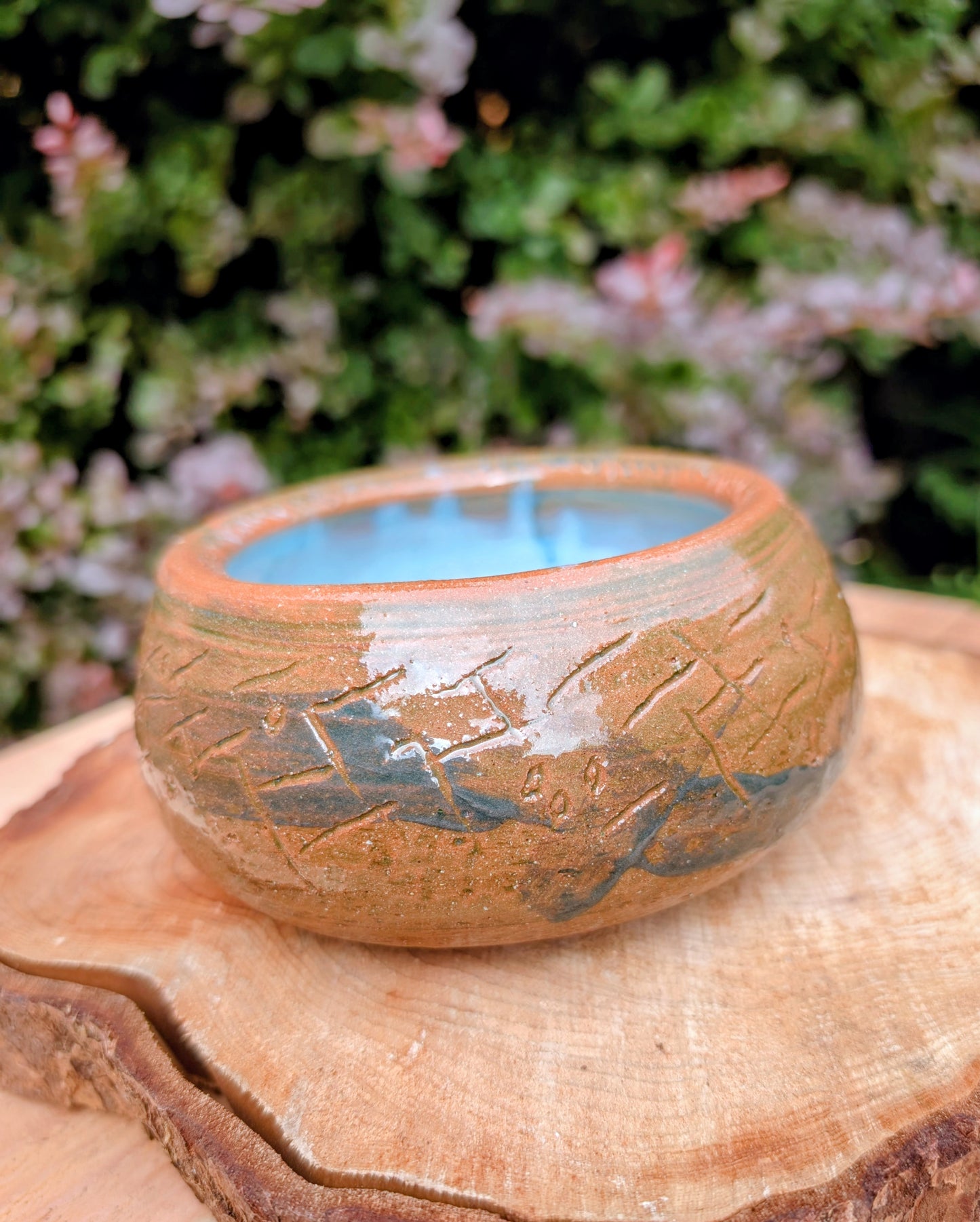 Handcrafted with richly carved texture and a soft blue reactive glaze, this signed studio pottery bowl brings warmth and character to any home. Ideal as a serving bowl, decorative accent, or functional piece of everyday artisan pottery.