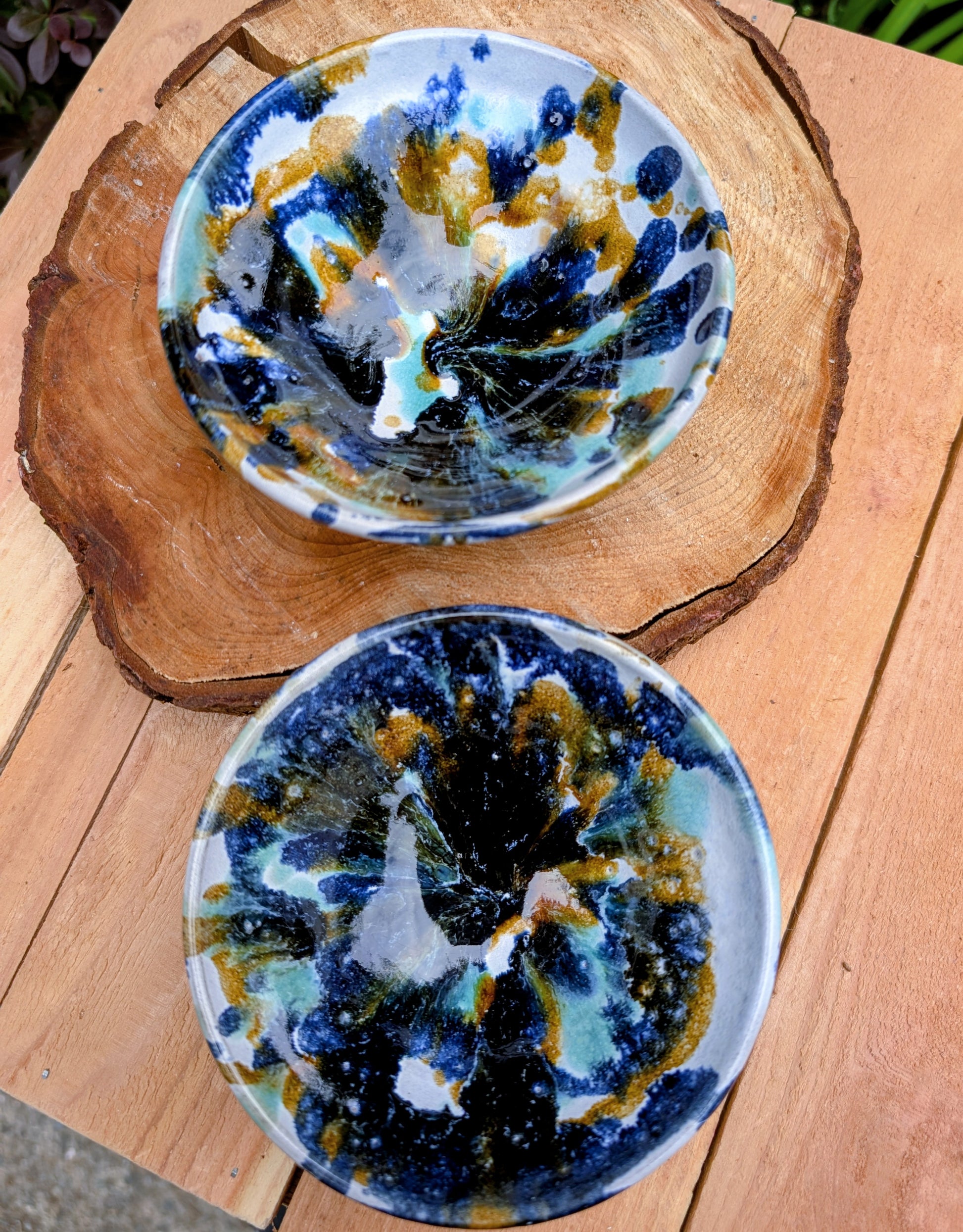 Bring handcrafted artistry to your table with this matching pair of signed studio pottery bowls. Finished with richly layered reactive glazes in cobalt blue, teal, amber, and ivory, these versatile artisan bowls are equally beautiful for entertaining or everyday display.
