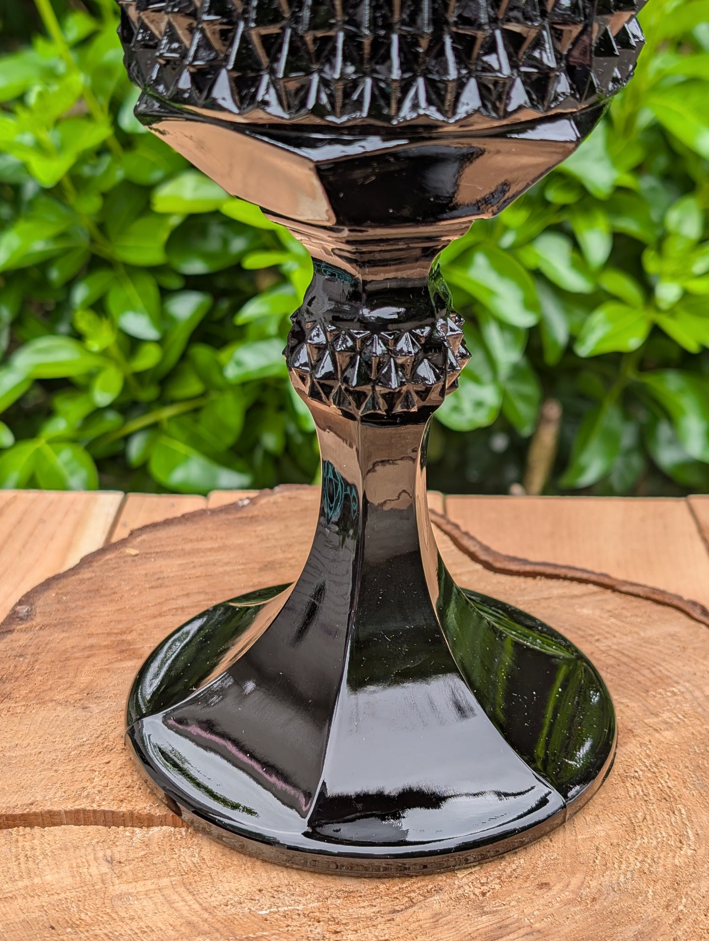Make a dramatic statement with this vintage Tiara Exclusives Diamond Point covered pedestal compote in rich Cameo Black glass. Standing an impressive 16 inches tall, this elegant pressed glass piece is perfect for displaying wrapped candies, seasonal décor, ornaments, or treasured collectibles throughout the year.