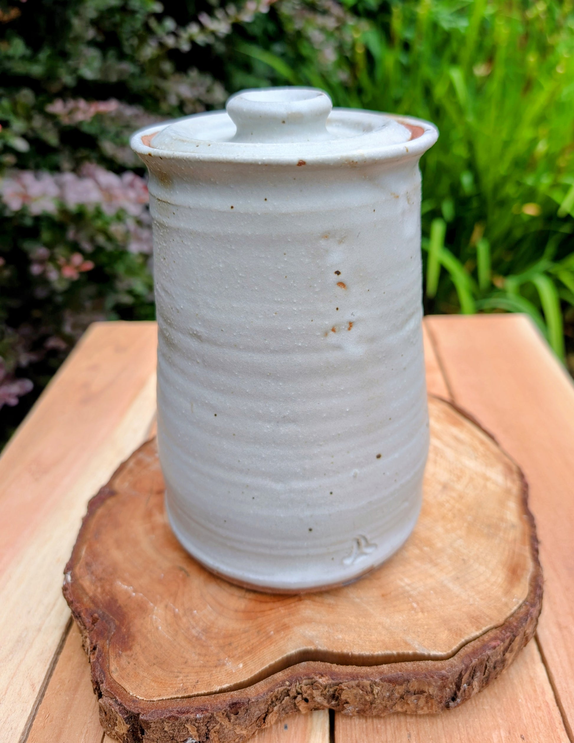 Bring warmth and handcrafted character to your kitchen with this wheel-thrown stoneware canister. Finished in a soft creamy-white glaze with subtle iron speckling, this timeless storage vessel blends rustic craftsmanship with modern organic design.