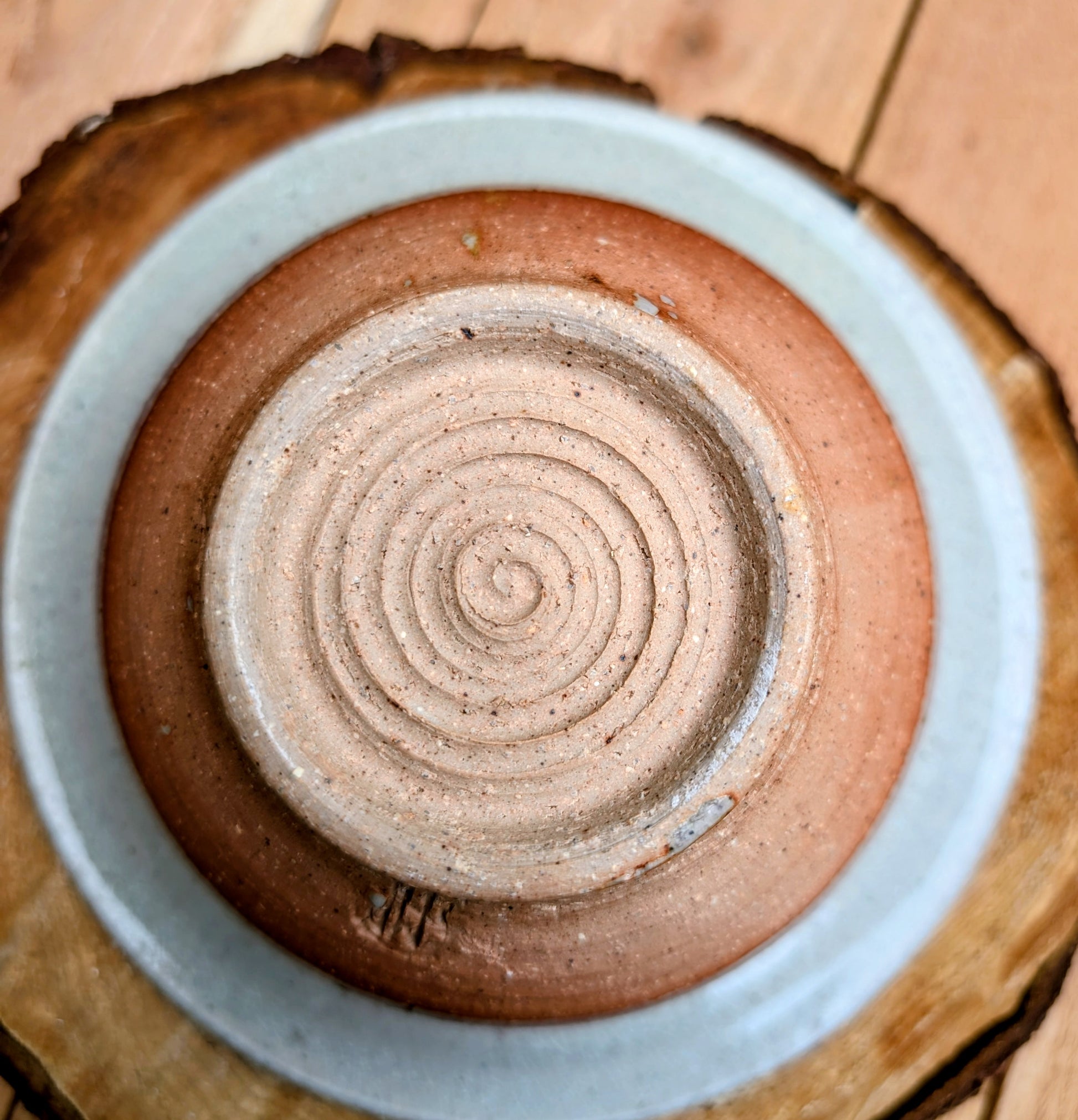 Handcrafted with timeless simplicity, this signed studio pottery serving bowl pairs a soft celadon-gray glaze with a warm iron-rich stoneware body. Its versatile size and understated design make it equally beautiful for serving, display, or everyday living.