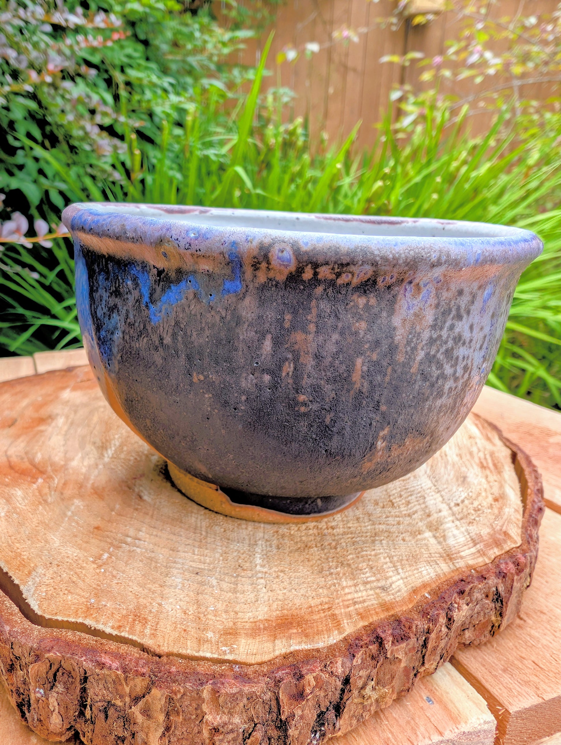Bring handcrafted artistry to your home with this small footed studio pottery bowl featuring layered reactive glazes in purple, blue, charcoal, and earthy brown. Wheel-thrown from high-fired stoneware, its one-of-a-kind finish makes it equally beautiful as functional tableware or decorative art.