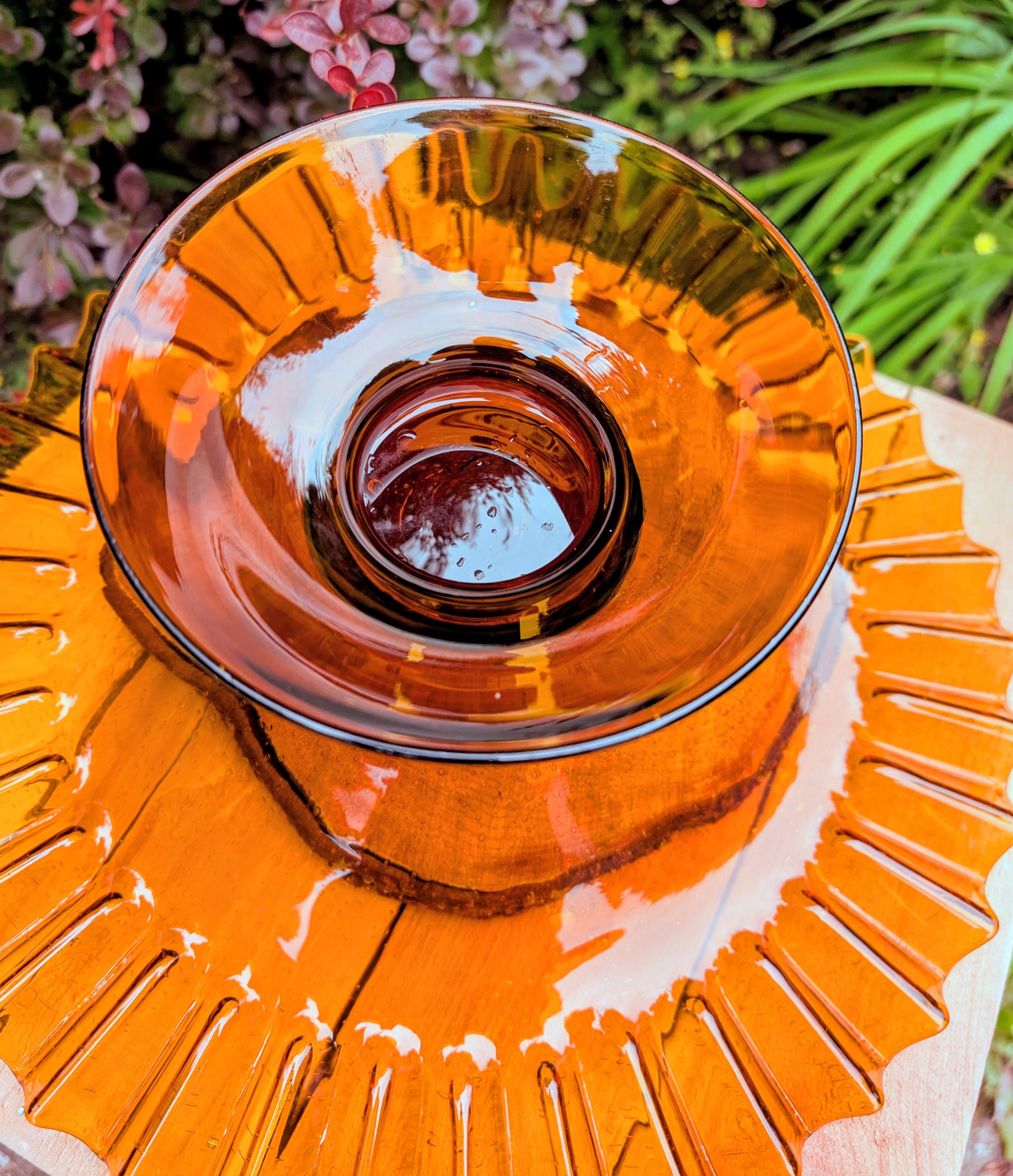 Bring warm vintage charm to your home with this large amber pressed glass pedestal console bowl, estimated to have been made by Indiana Glass during the 1960s–1970s. Its dramatic ruffled rim and generous size make it a beautiful centerpiece for seasonal displays, fruit, florals, or decorative accents throughout the year.