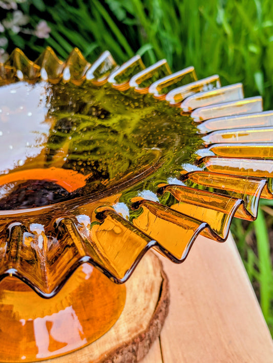 Bring warm vintage charm to your home with this large amber pressed glass pedestal console bowl, estimated to have been made by Indiana Glass during the 1960s–1970s. Its dramatic ruffled rim and generous size make it a beautiful centerpiece for seasonal displays, fruit, florals, or decorative accents throughout the year.