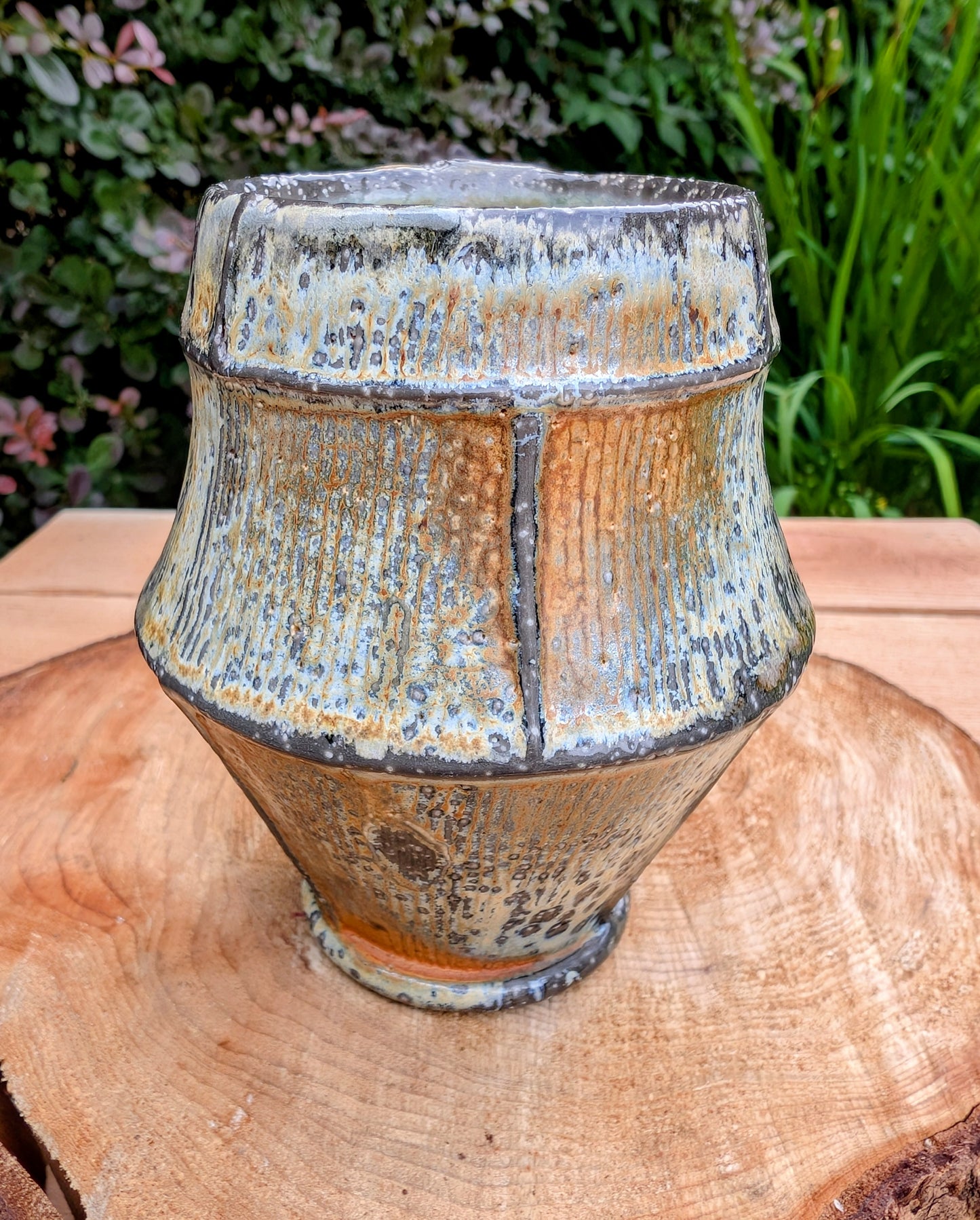 Celebrate slow mornings with this handcrafted faceted studio pottery mug, featuring a richly layered volcanic glaze and a soft celadon-green interior. Its sculptural form and earthy palette make it equally beautiful in the hand or displayed as functional art.