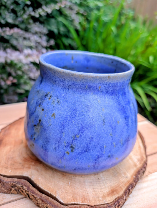 Handcrafted and artist-signed, this wheel-thrown stoneware vessel features a rich satin matte cobalt blue glaze accented with natural iron speckling. Originally created as a lidded storage jar, it now serves beautifully as a versatile open vessel for display or everyday use.