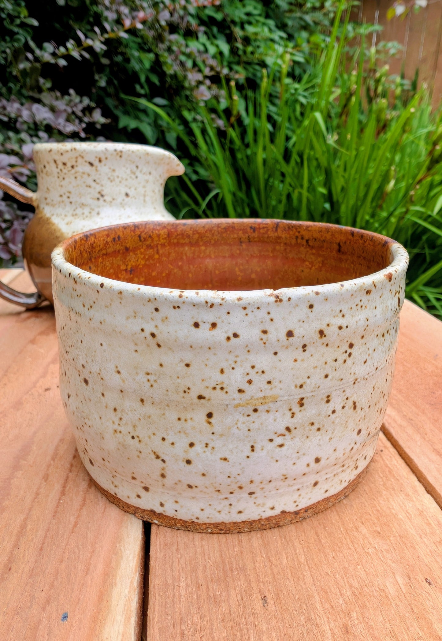 Bring handcrafted warmth to your table with this signed studio pottery creamer and sugar bowl set. Finished in a beautiful speckled cream glaze with flowing olive-brown accents, this artisan stoneware pair blends rustic craftsmanship with timeless everyday function.