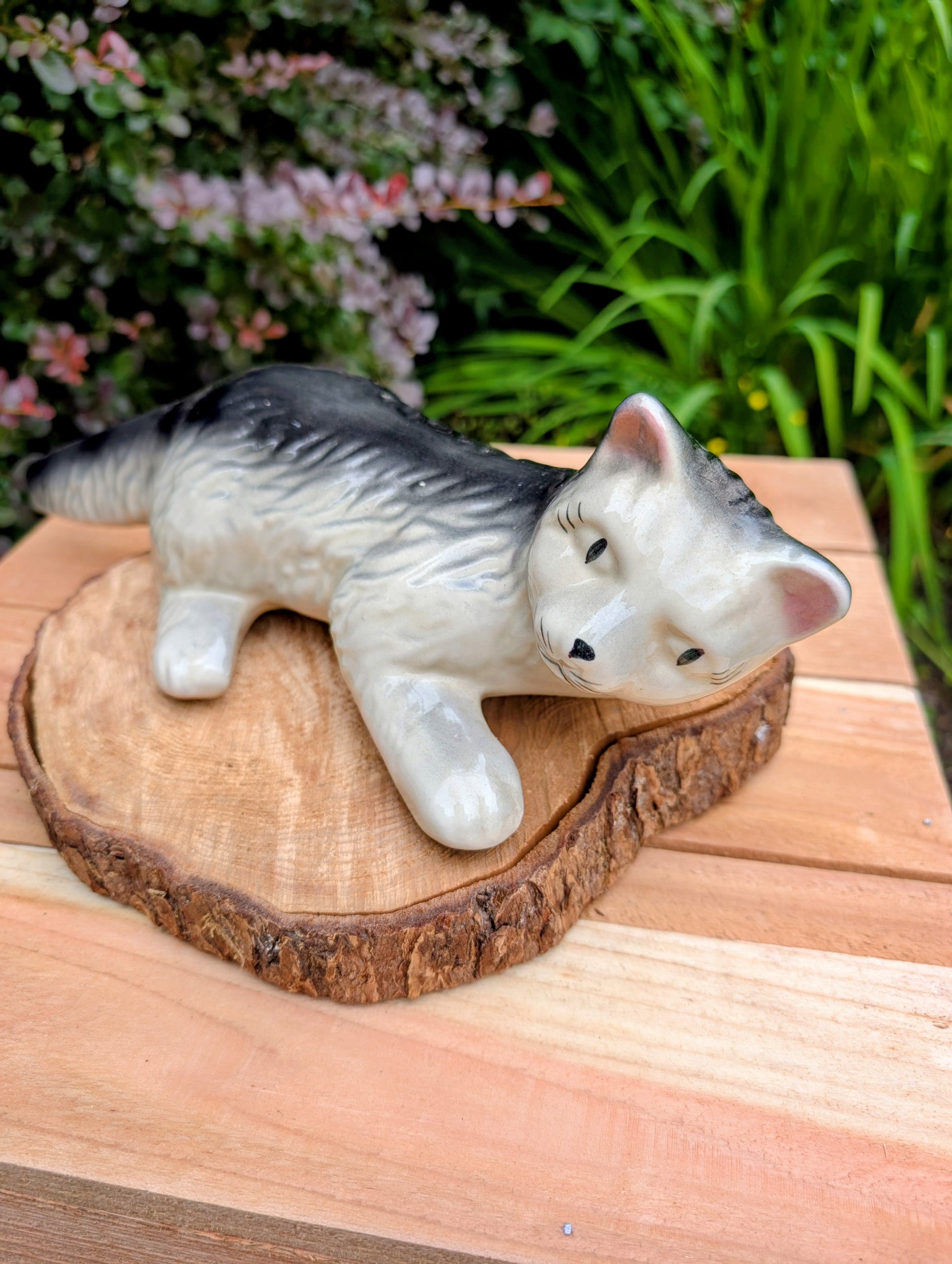 Bring a touch of mid-century whimsy to your home or garden with this vintage hand-painted ceramic wall hugger cat. Its generous 14-inch size, expressive face, and glossy gray-and-black finish make it a charming collectible for cat lovers and vintage décor enthusiasts alike.
