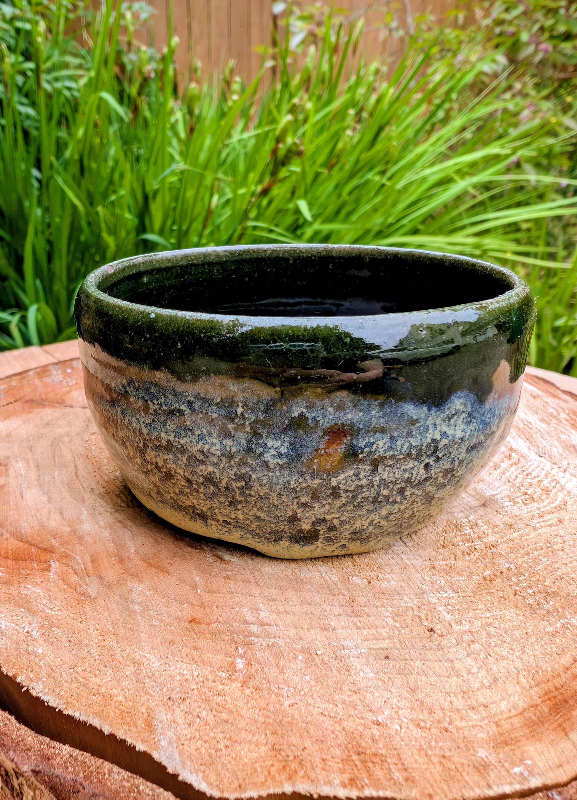 A beautifully hand-thrown studio pottery bowl featuring a rich olive green interior and layered blue, cream, and earthy brown glaze. Signed by the artist, this compact stoneware piece blends functional craftsmanship with timeless Pacific Northwest style.