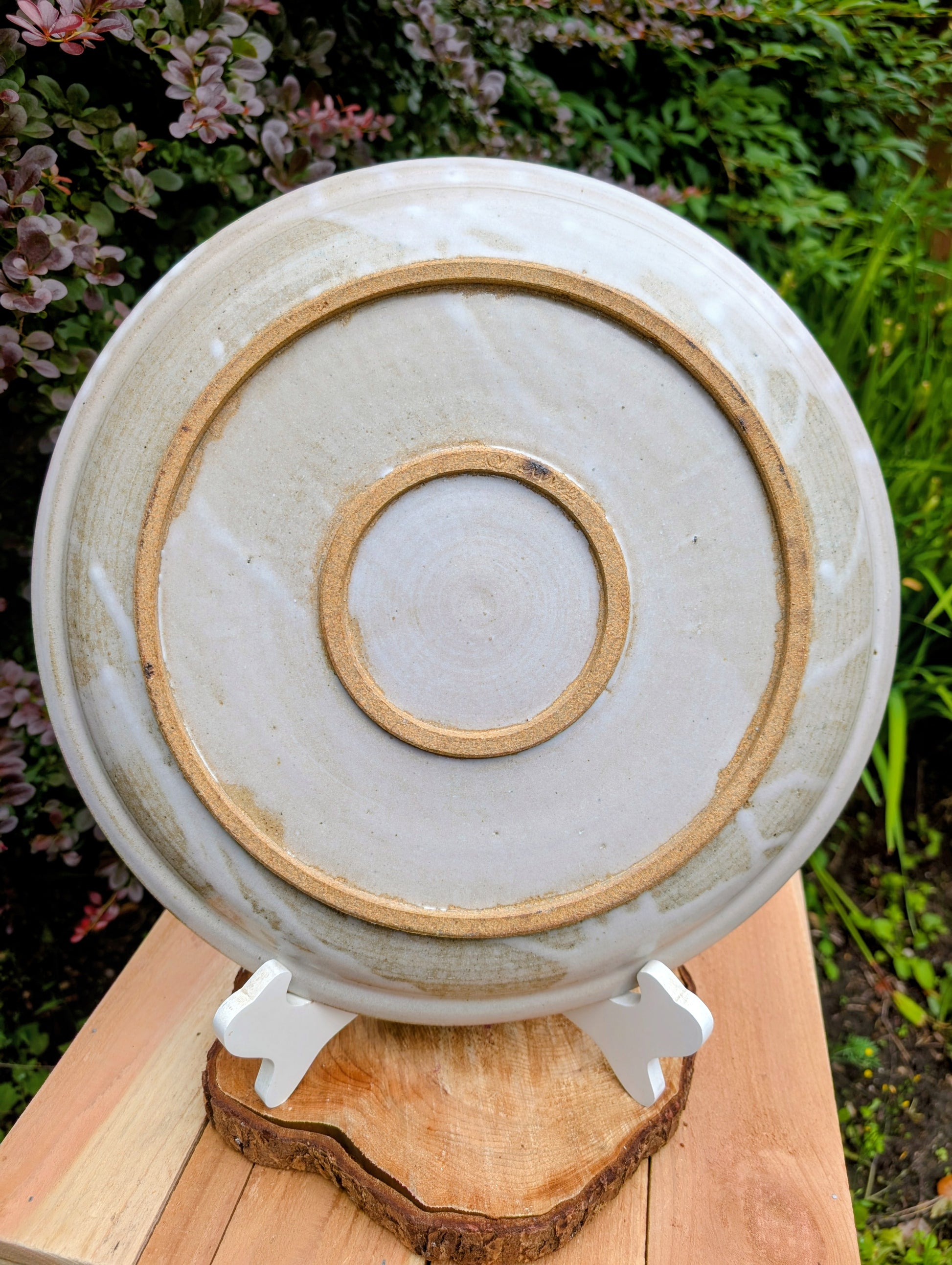 A beautifully hand-thrown studio pottery platter featuring expressive blue-gray and olive brushwork over a soft neutral glaze. Its generous size and timeless craftsmanship make it equally suited for serving, display, or as striking wall décor.