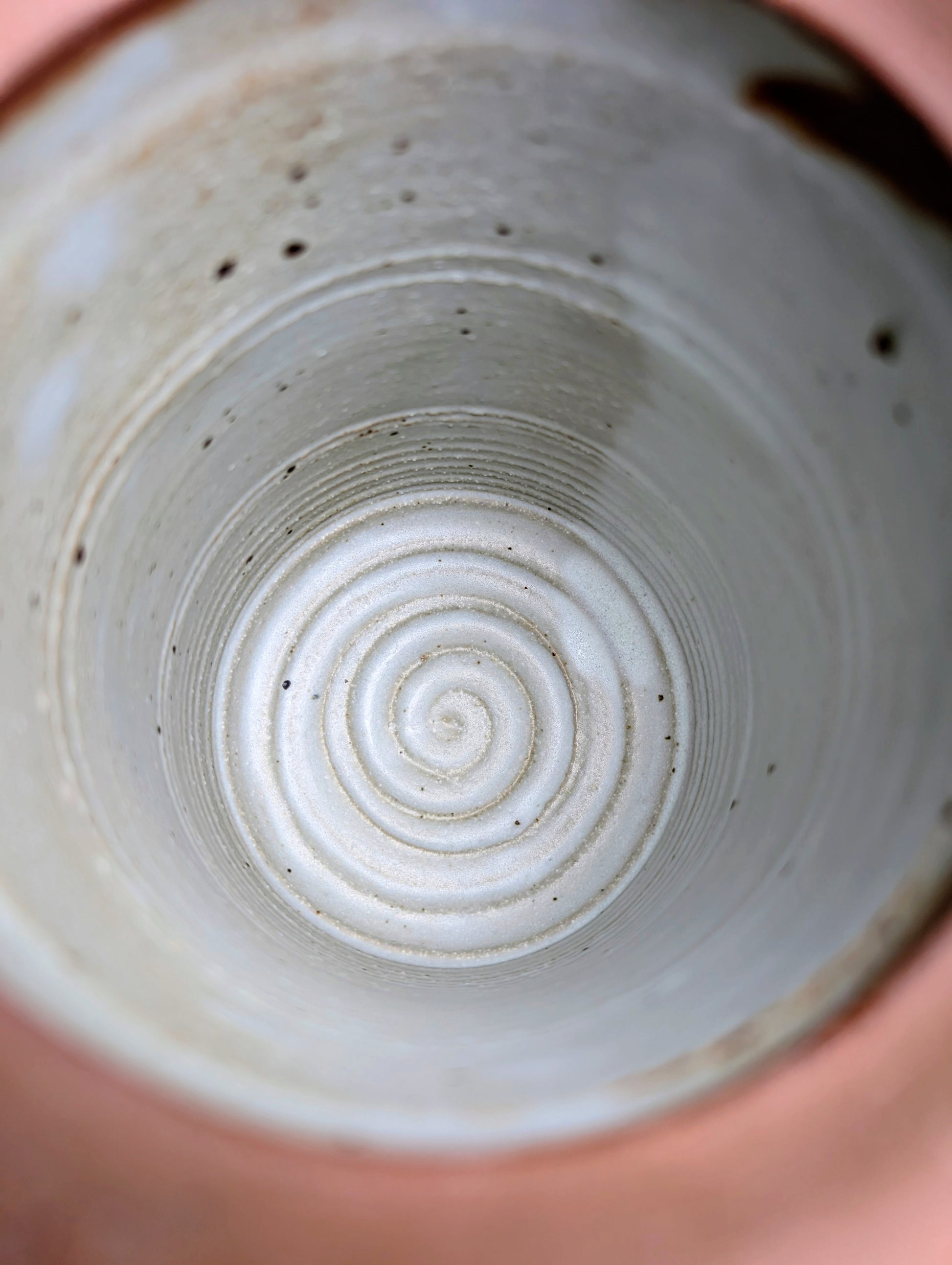 Bring warmth and handcrafted character to your kitchen with this wheel-thrown stoneware canister. Finished in a soft creamy-white glaze with subtle iron speckling, this timeless storage vessel blends rustic craftsmanship with modern organic design.