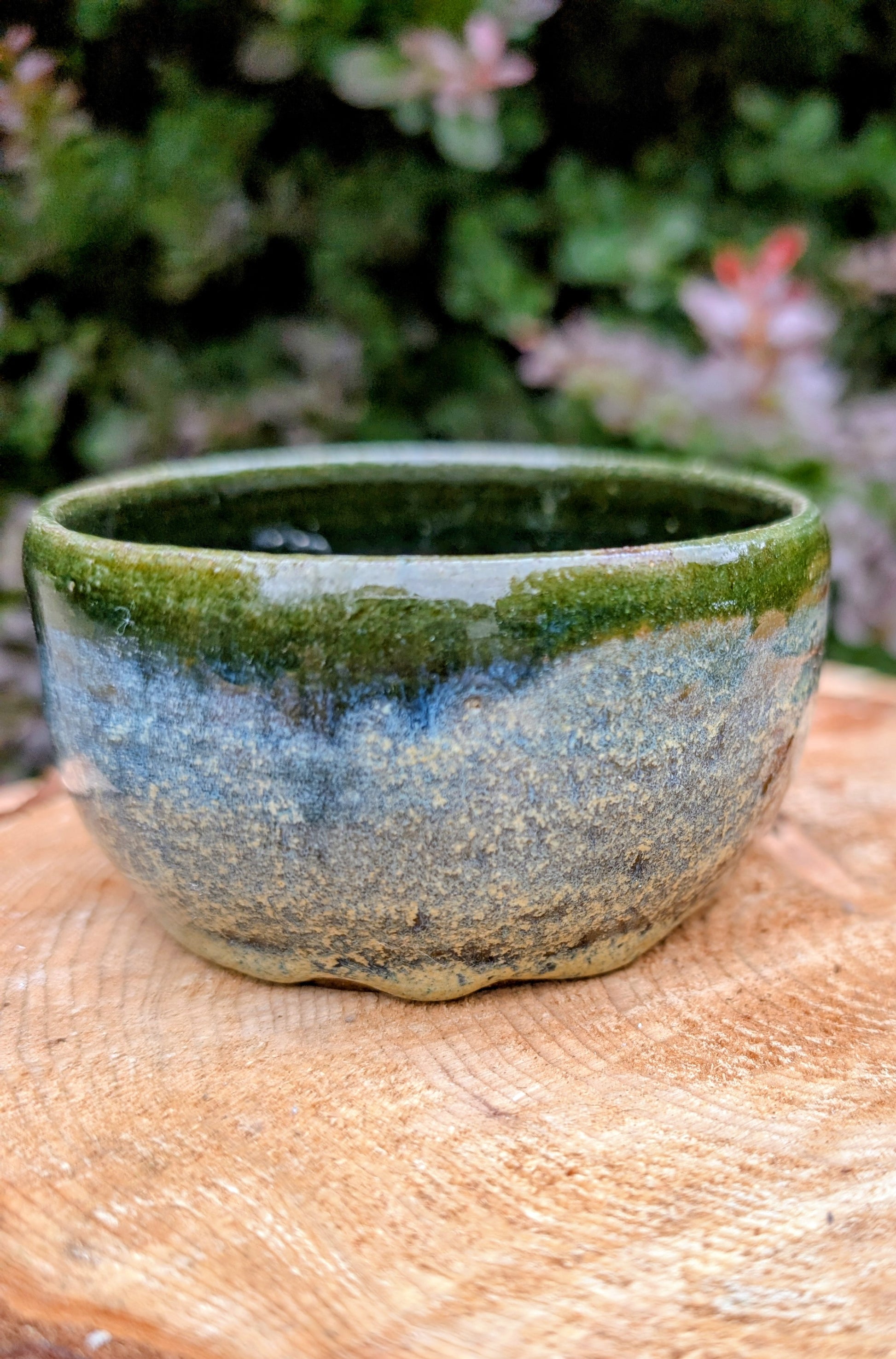 A beautifully hand-thrown studio pottery bowl featuring a rich olive green interior and layered blue, cream, and earthy brown glaze. Signed by the artist, this compact stoneware piece blends functional craftsmanship with timeless Pacific Northwest style.