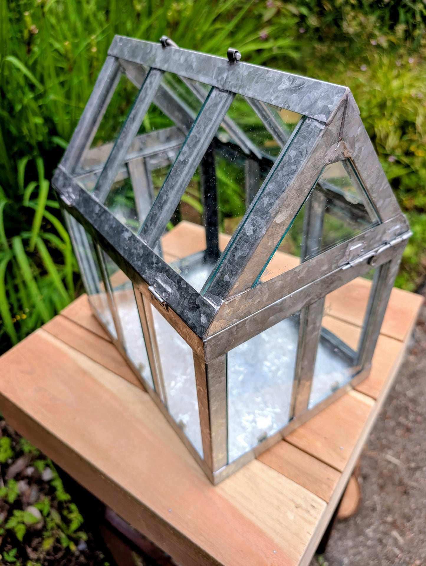 Bring the charm of a Victorian conservatory indoors with this decorative galvanized metal and glass tabletop greenhouse. Perfect for displaying succulents, moss gardens, candles, seasonal décor, or treasured collectibles, it adds timeless botanical style to any room.