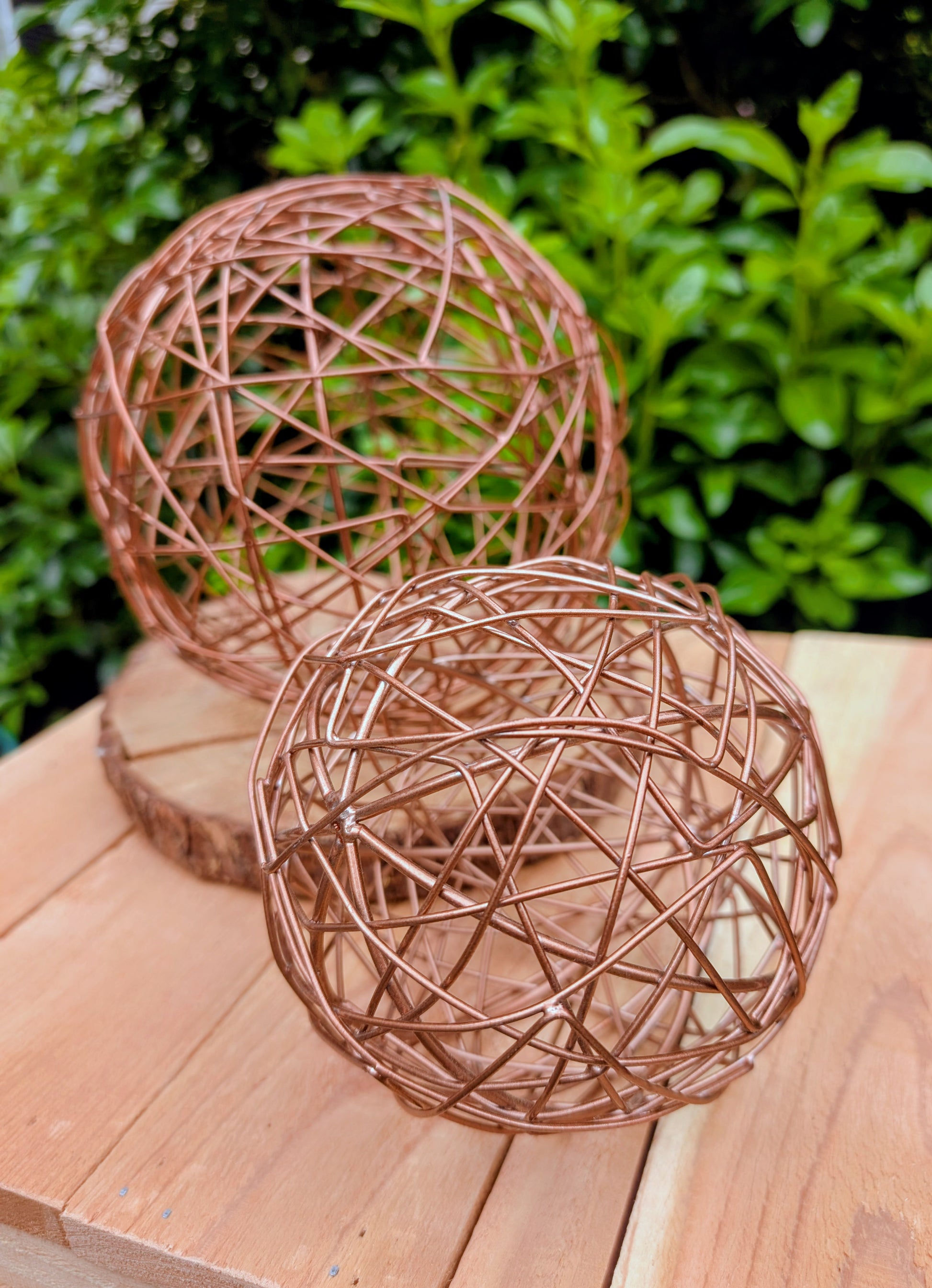 Bring warmth and texture to your home with this coordinated set of two copper-tone woven metal decorative spheres. Their sculptural open-weave design complements modern organic, farmhouse, industrial, and contemporary interiors, making them versatile accents for shelves, coffee tables, decorative bowls, and centerpieces.