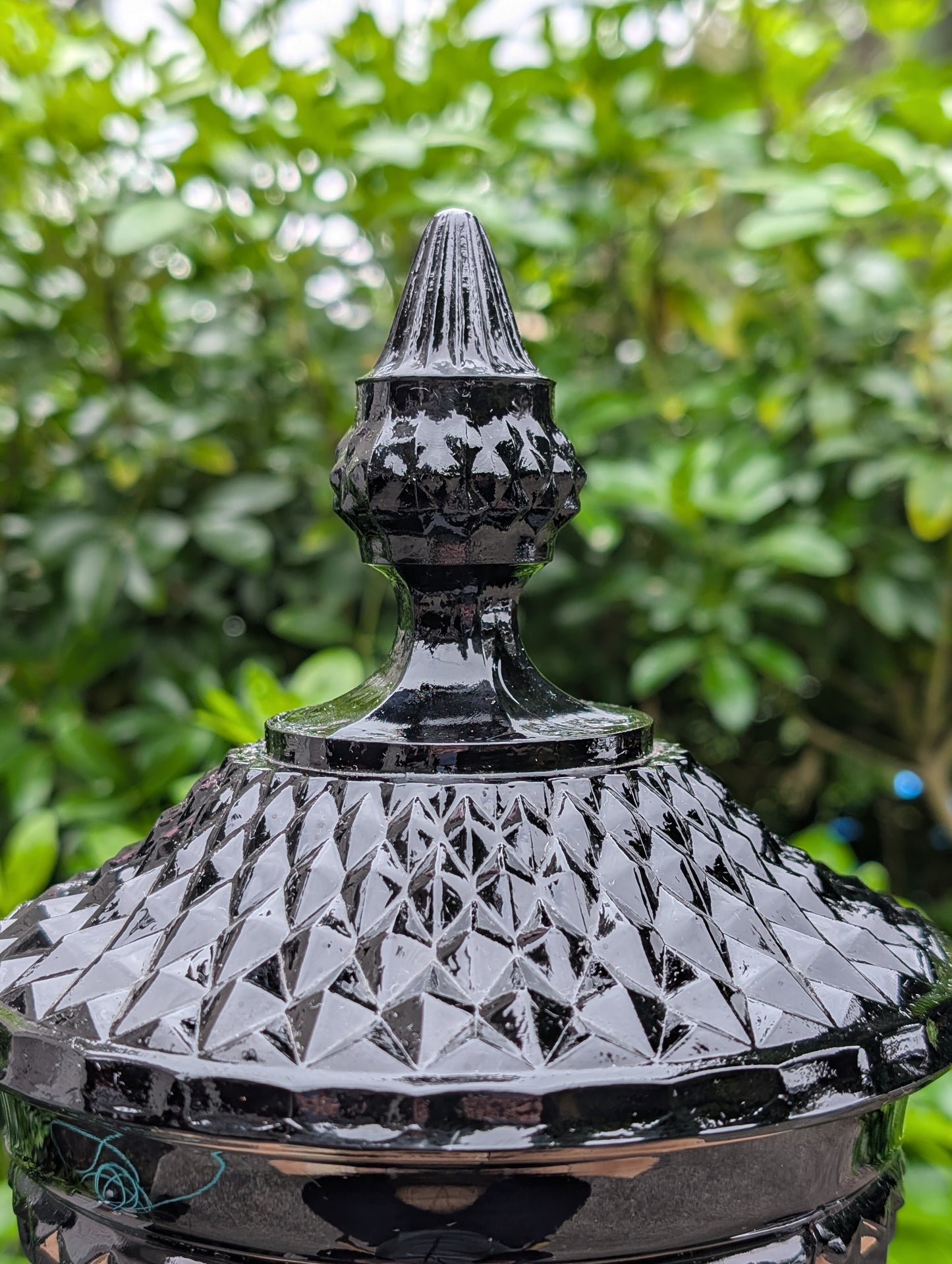 Make a dramatic statement with this vintage Tiara Exclusives Diamond Point covered pedestal compote in rich Cameo Black glass. Standing an impressive 16 inches tall, this elegant pressed glass piece is perfect for displaying wrapped candies, seasonal décor, ornaments, or treasured collectibles throughout the year.