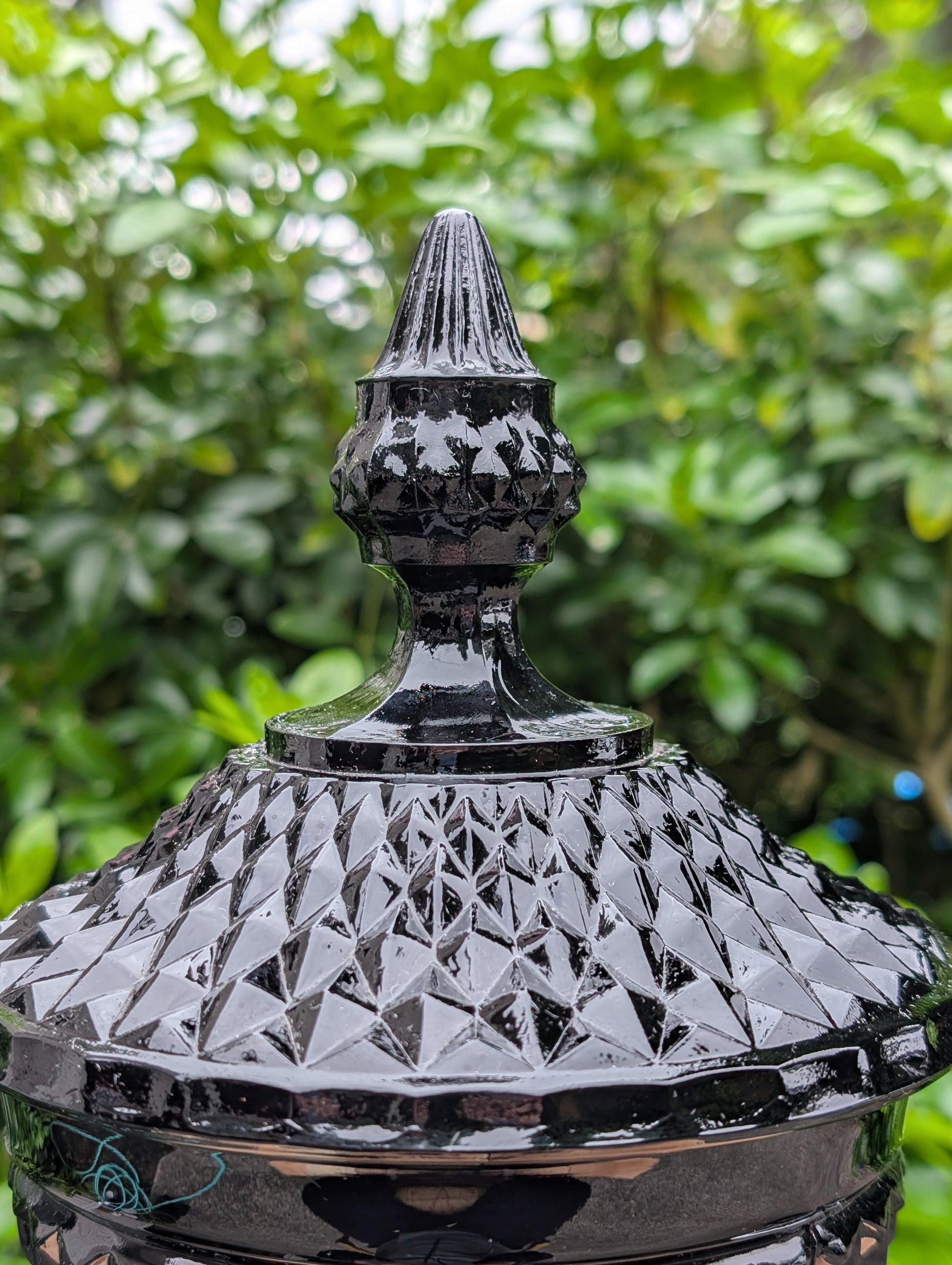 Make a dramatic statement with this vintage Tiara Exclusives Diamond Point covered pedestal compote in rich Cameo Black glass. Standing an impressive 16 inches tall, this elegant pressed glass piece is perfect for displaying wrapped candies, seasonal décor, ornaments, or treasured collectibles throughout the year.