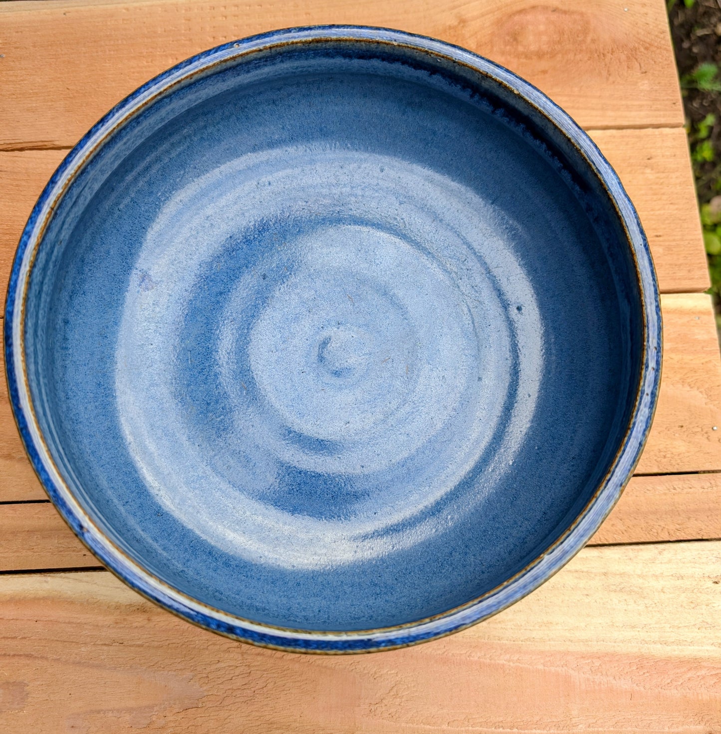 A beautifully hand-thrown studio pottery bowl dated 1990, featuring a rich satin cobalt blue glaze with a subtle spiral movement across the interior. Signed by the artist (maker currently unconfirmed), this functional stoneware piece blends everyday usefulness with timeless handcrafted artistry.
