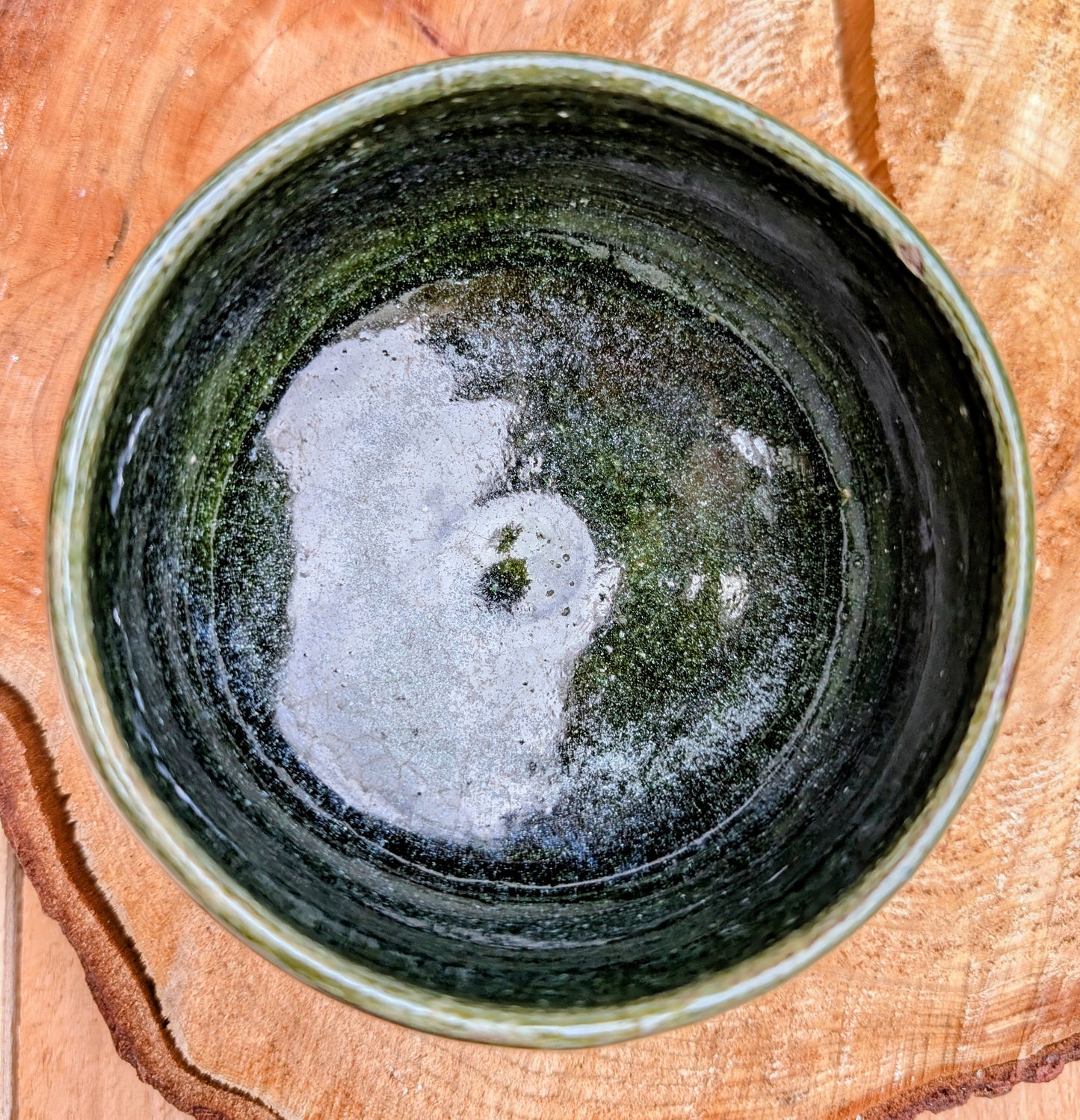 A beautifully hand-thrown studio pottery bowl featuring a rich olive green interior and layered blue, cream, and earthy brown glaze. Signed by the artist, this compact stoneware piece blends functional craftsmanship with timeless Pacific Northwest style.