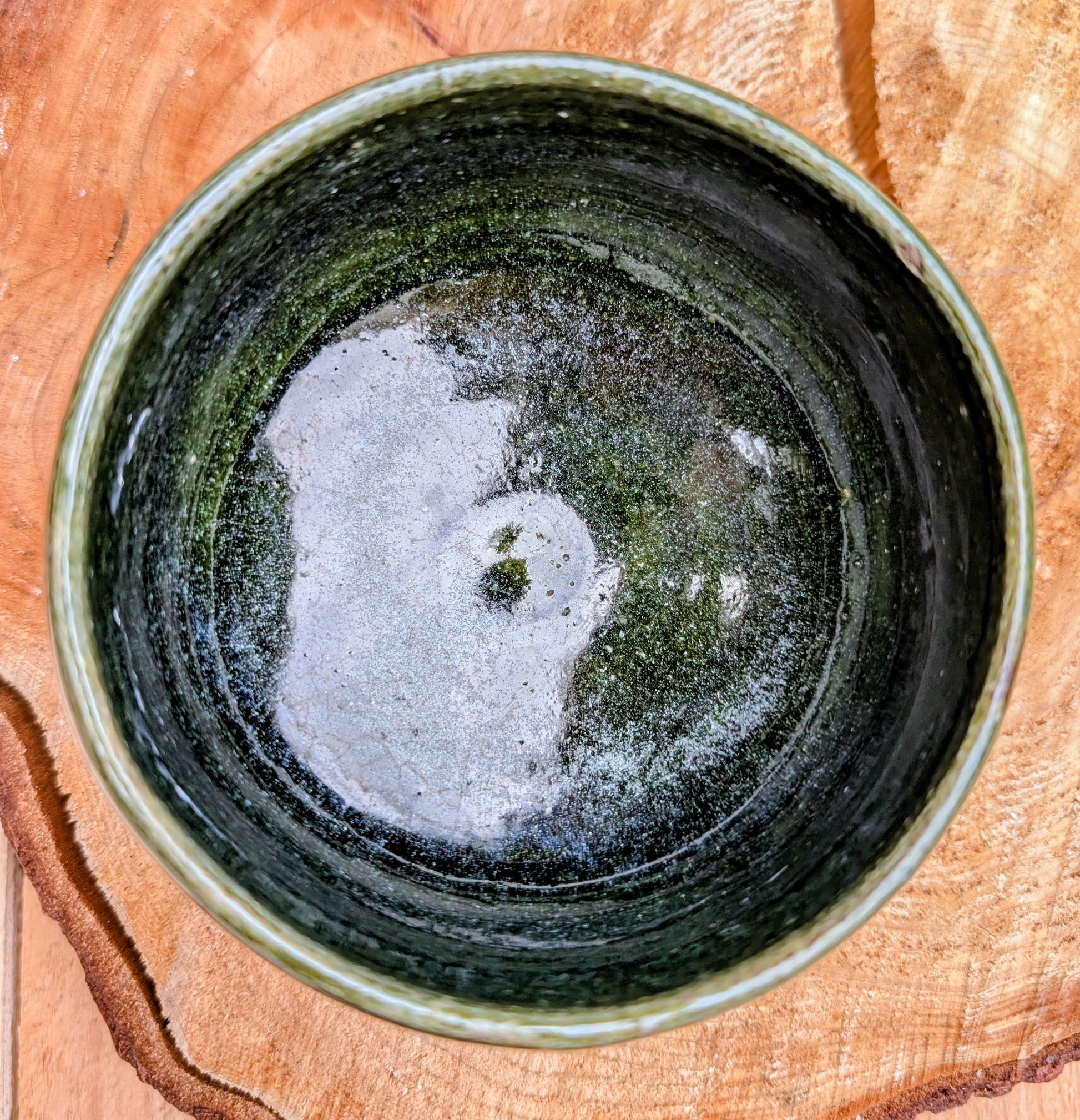 A beautifully hand-thrown studio pottery bowl featuring a rich olive green interior and layered blue, cream, and earthy brown glaze. Signed by the artist, this compact stoneware piece blends functional craftsmanship with timeless Pacific Northwest style.